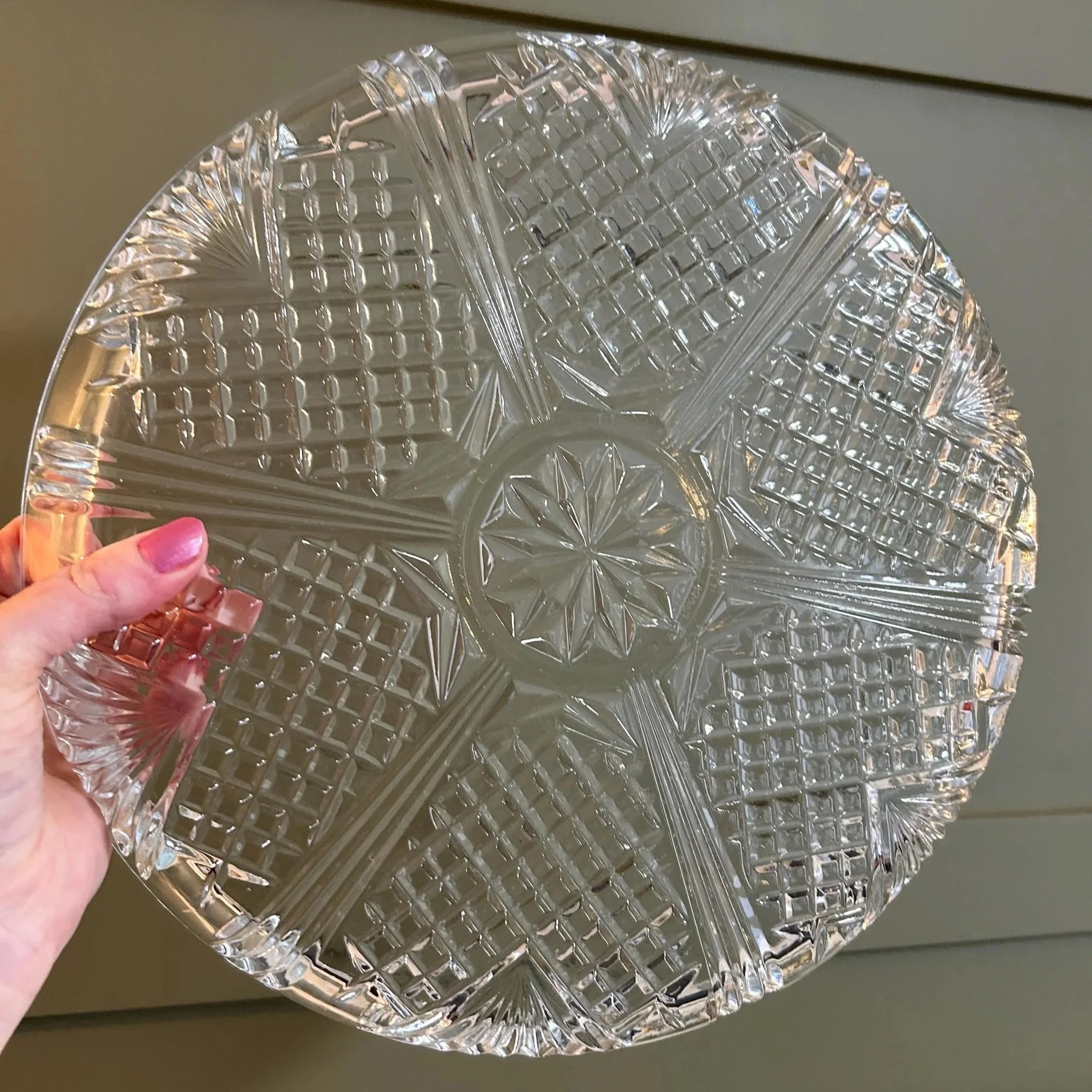 Crystal platter with strong light reflection showing cut pattern clarity.