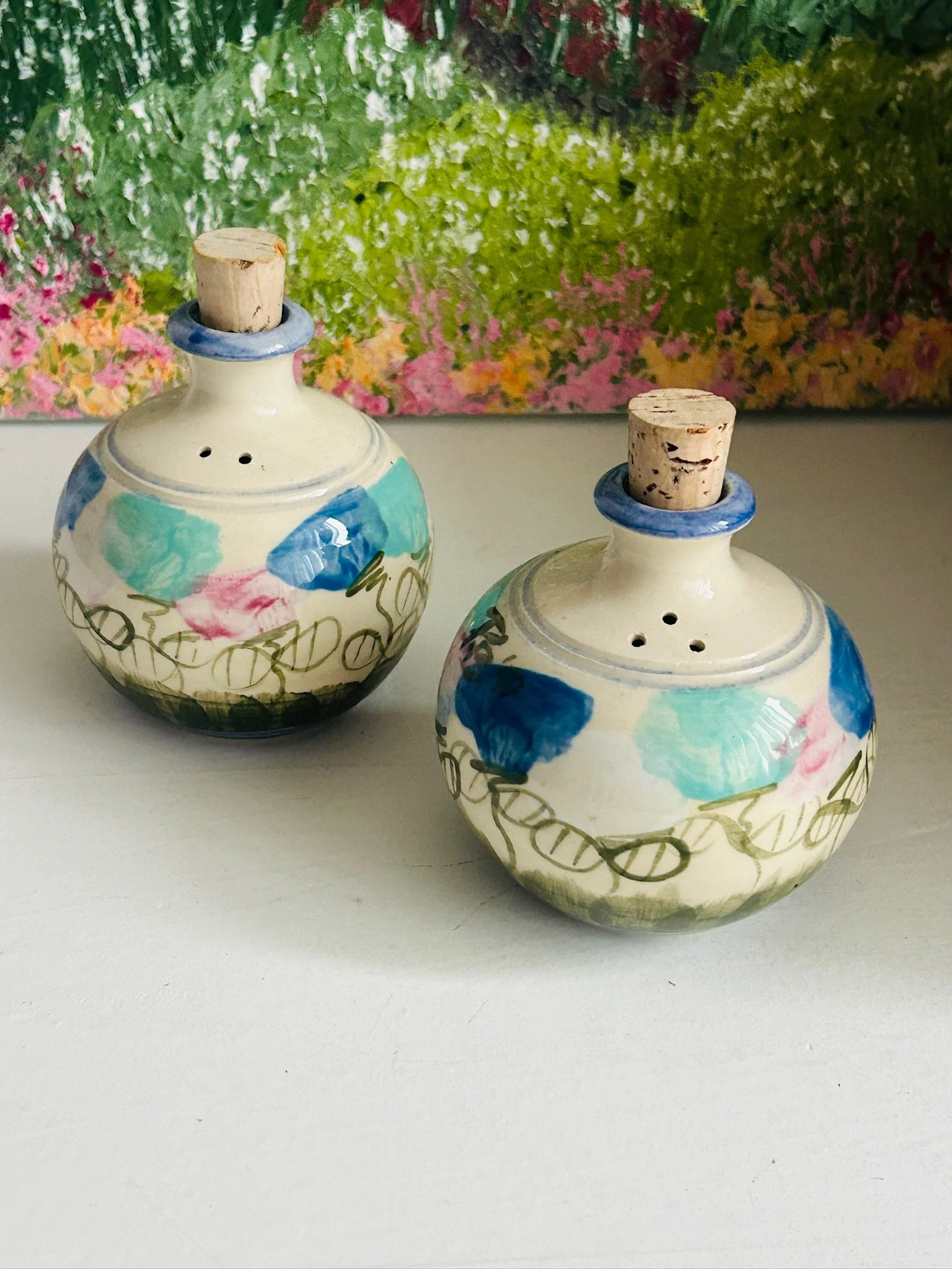 Two handcrafted Australian stoneware shakers shown side by side, highlighting the rounded shape and floral brushwork