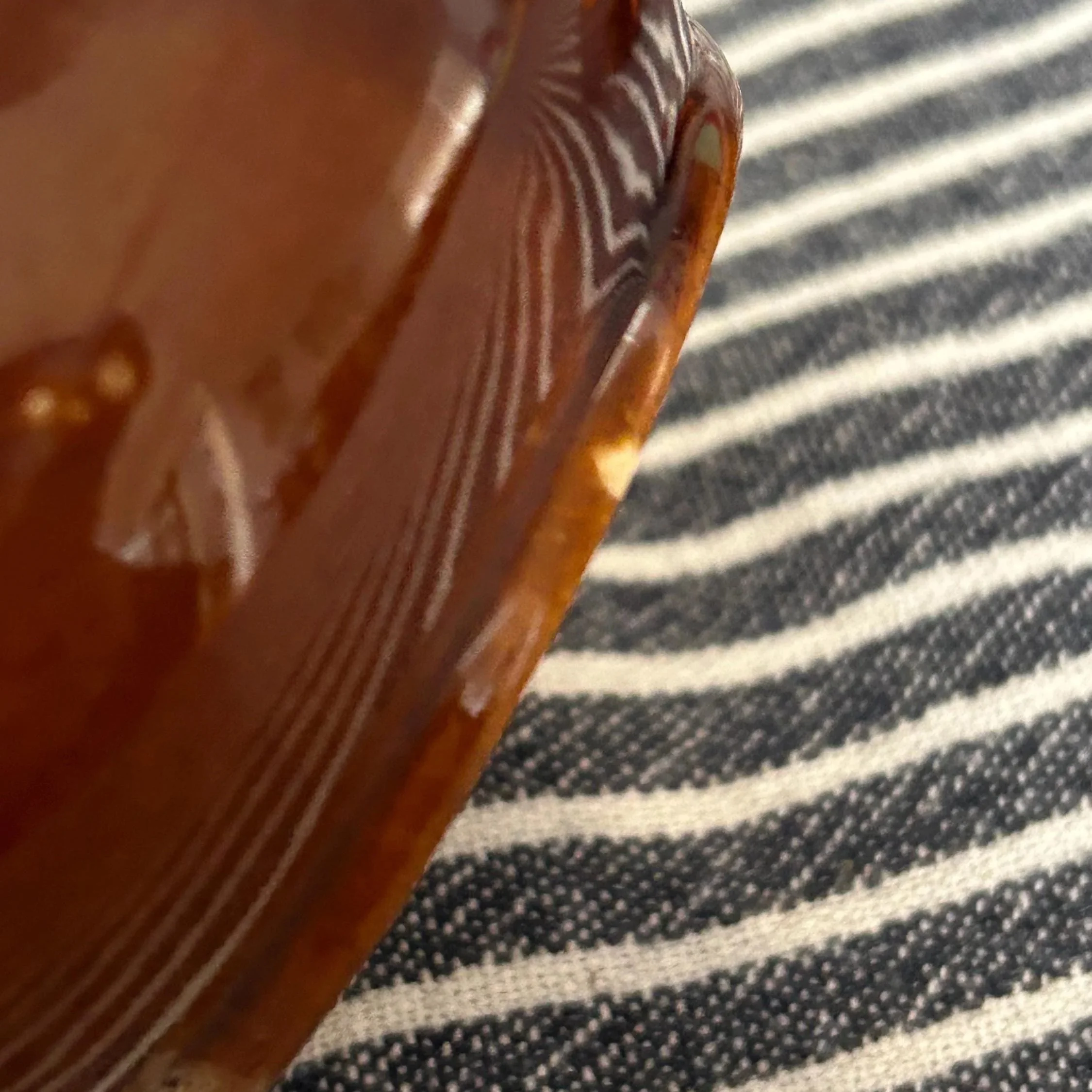Close-up of small chip on brown glaze with soft reflections