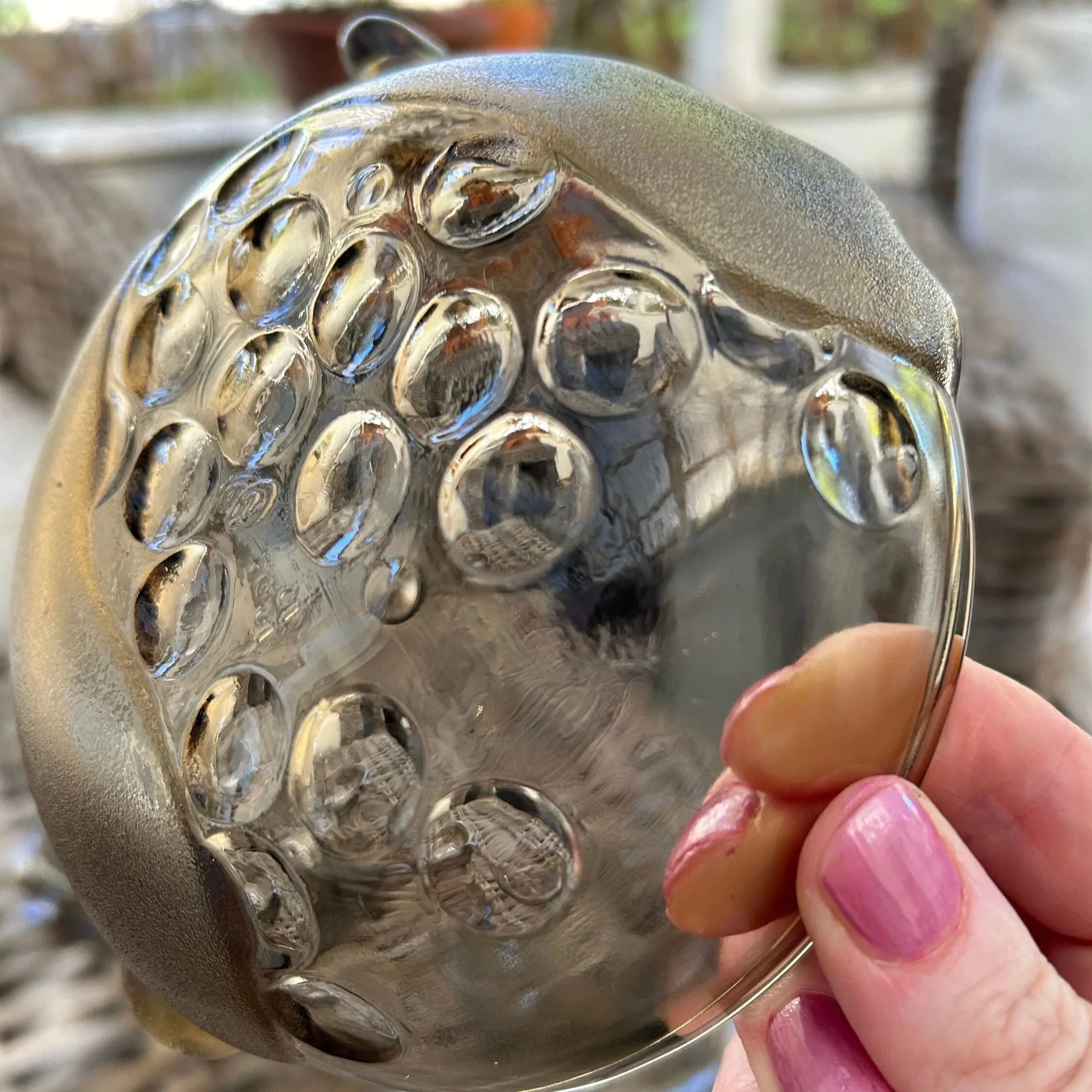 Hand holding bowl to highlight transparency and surface texture