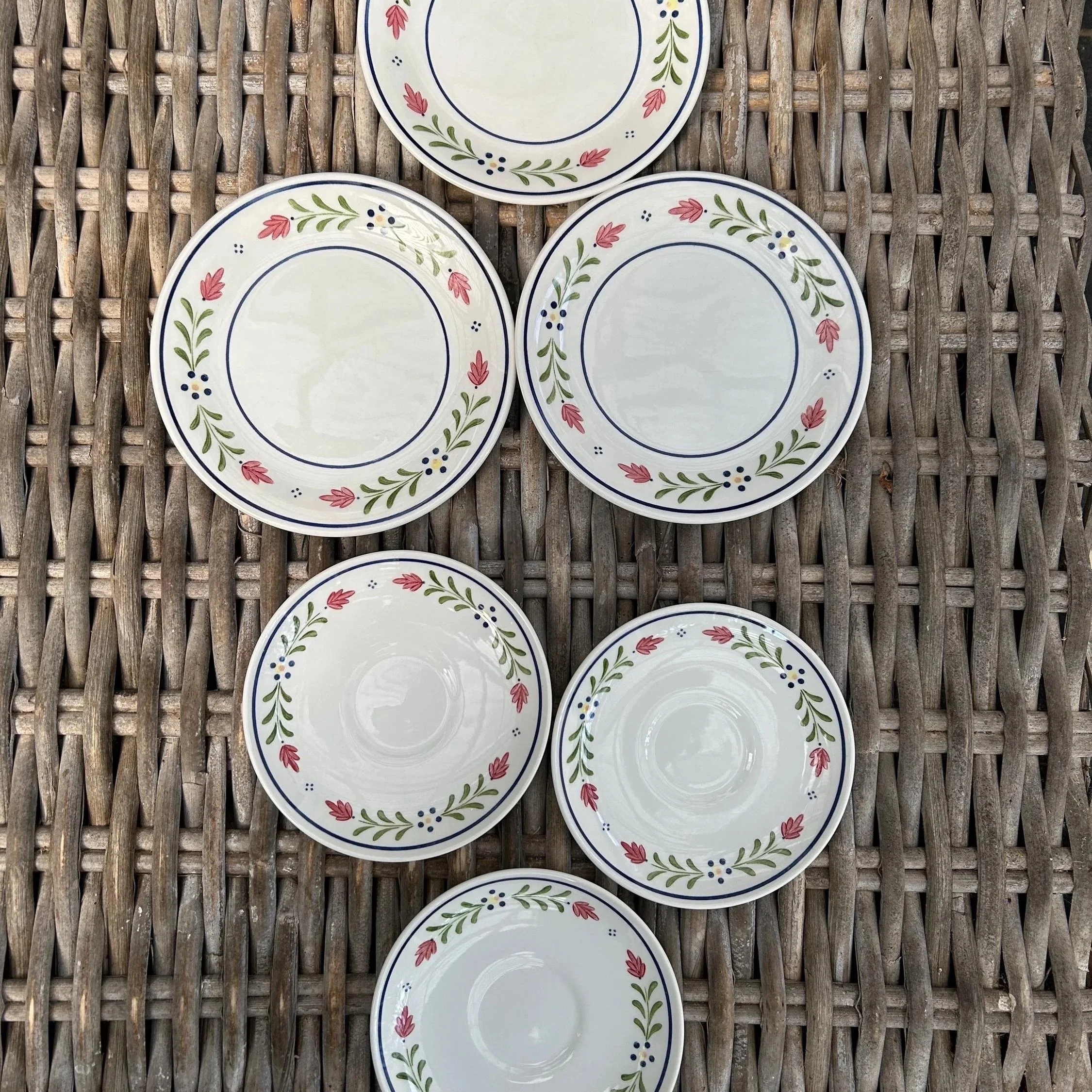 Overhead view of six Johnson Brothers ‘Provincial’ plates arranged on wicker background