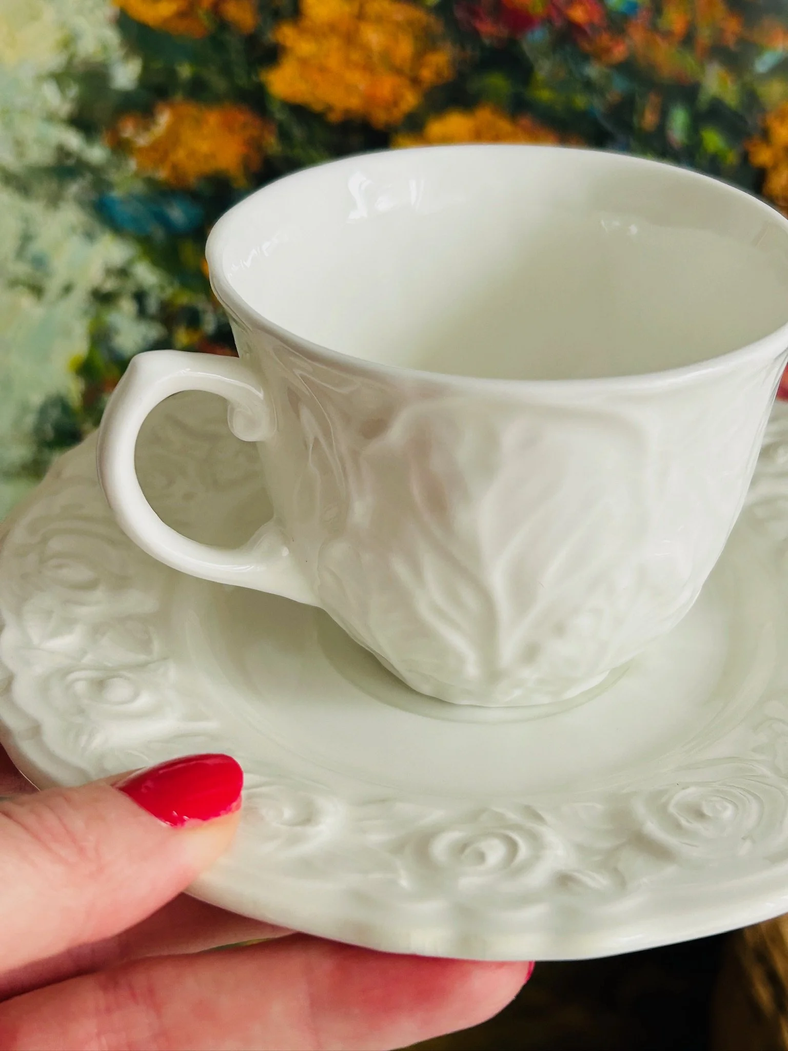 Close-up of the Wedgwood cup body, highlighting the raised cabbage-leaf style embossing in white porcelain.