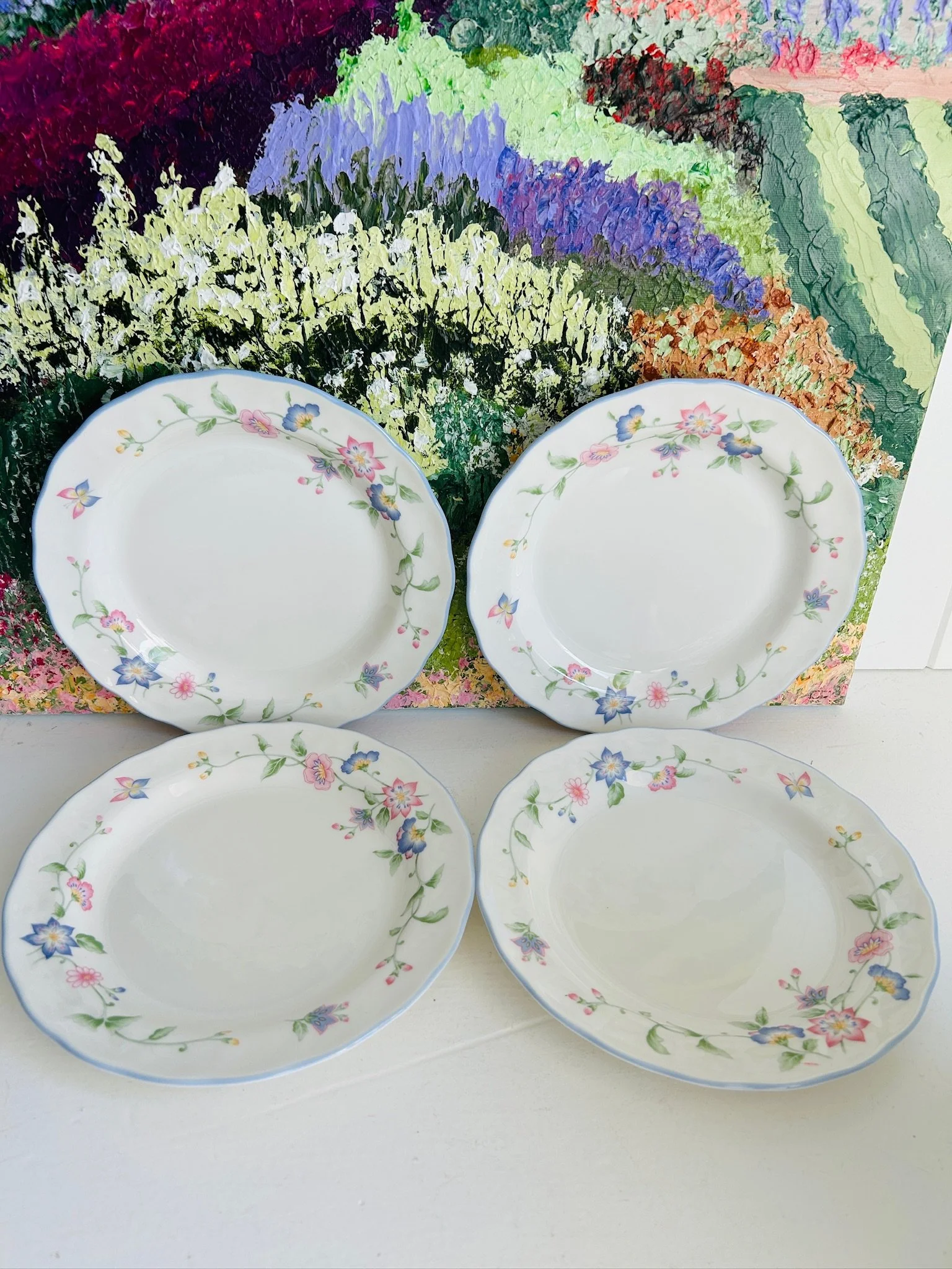 Full set of four Royal Doulton floral plates displayed together, showing matching size, shape, and pastel botanical pattern.