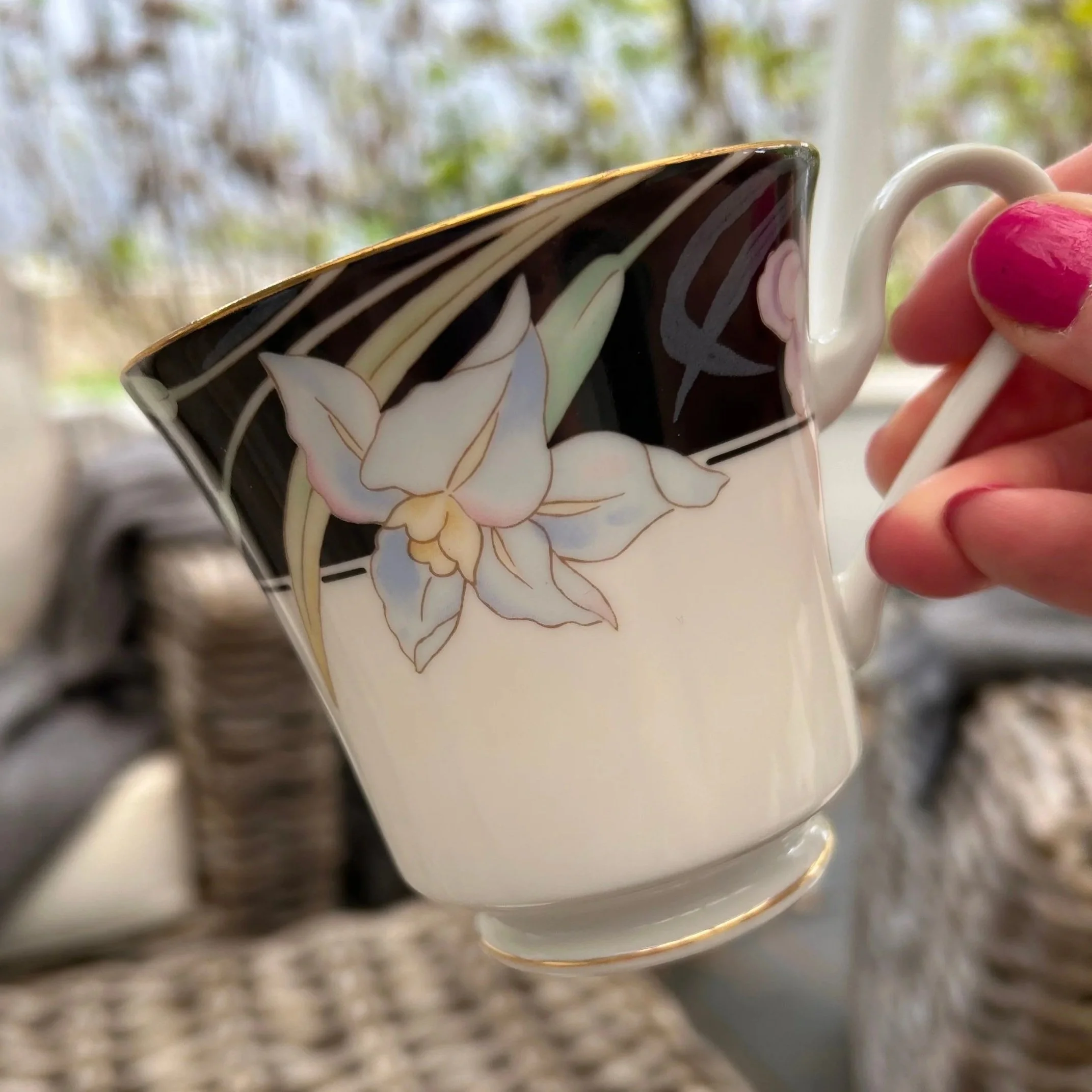 Side profile of tea cup held to show scale and pattern