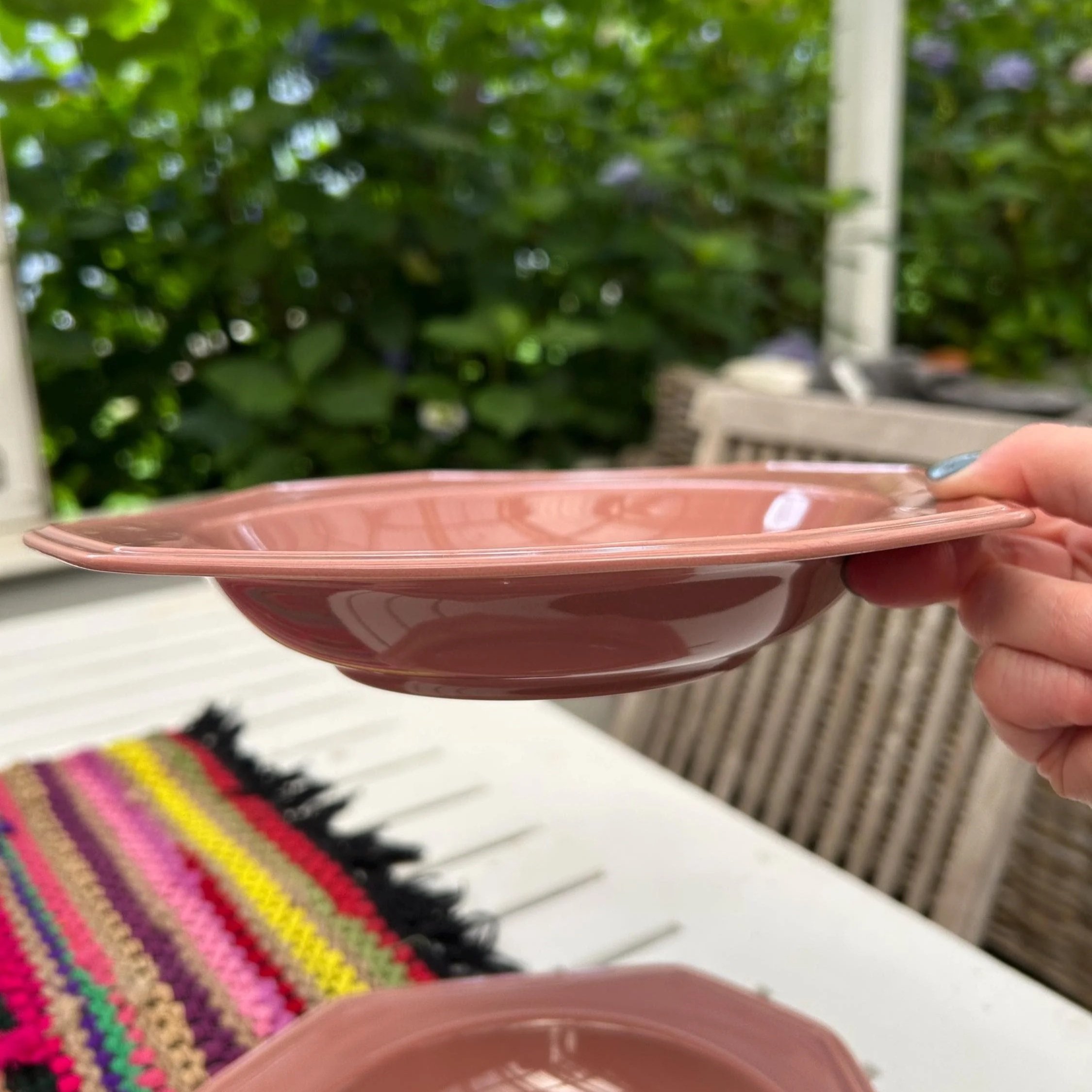 Side angle of a single bowl held to show octagonal rim