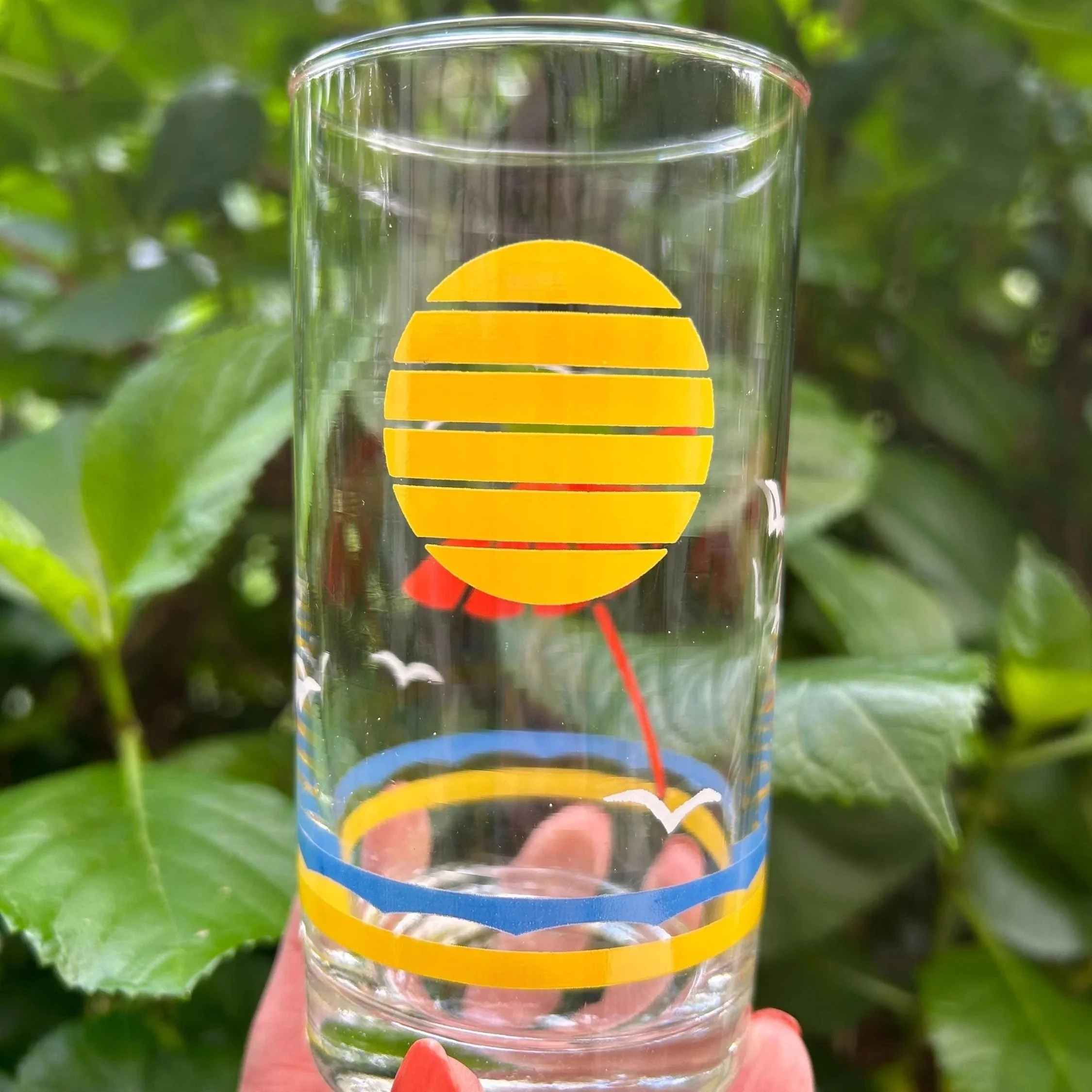 Detail of tumbler showing striped yellow sun design