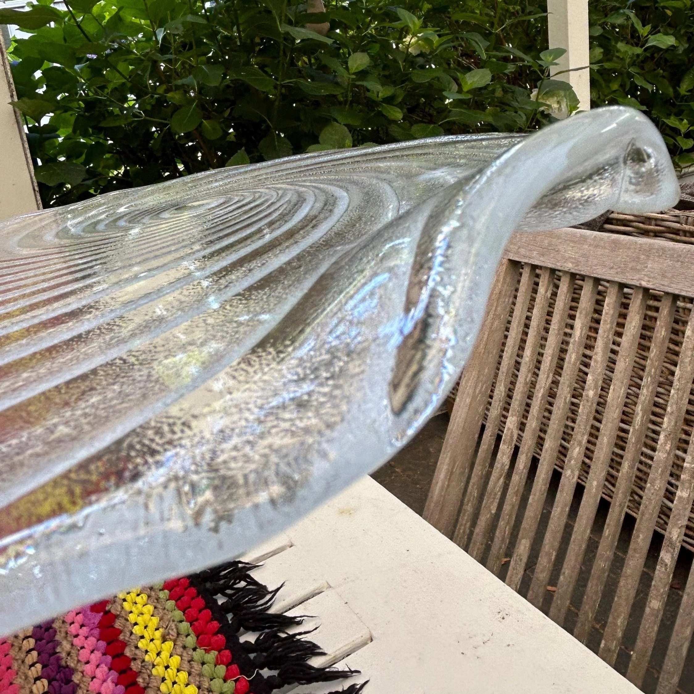 Close side view showing scalloped rim and curved handled edge.