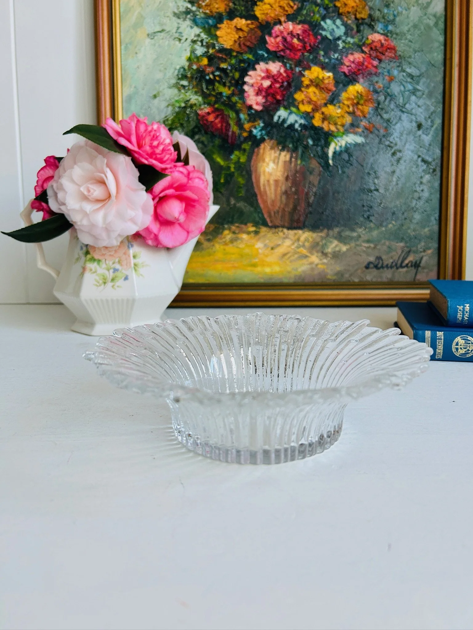 Humppila Revontulet dish styled on a white mantel with pink camellias and a floral oil painting behind