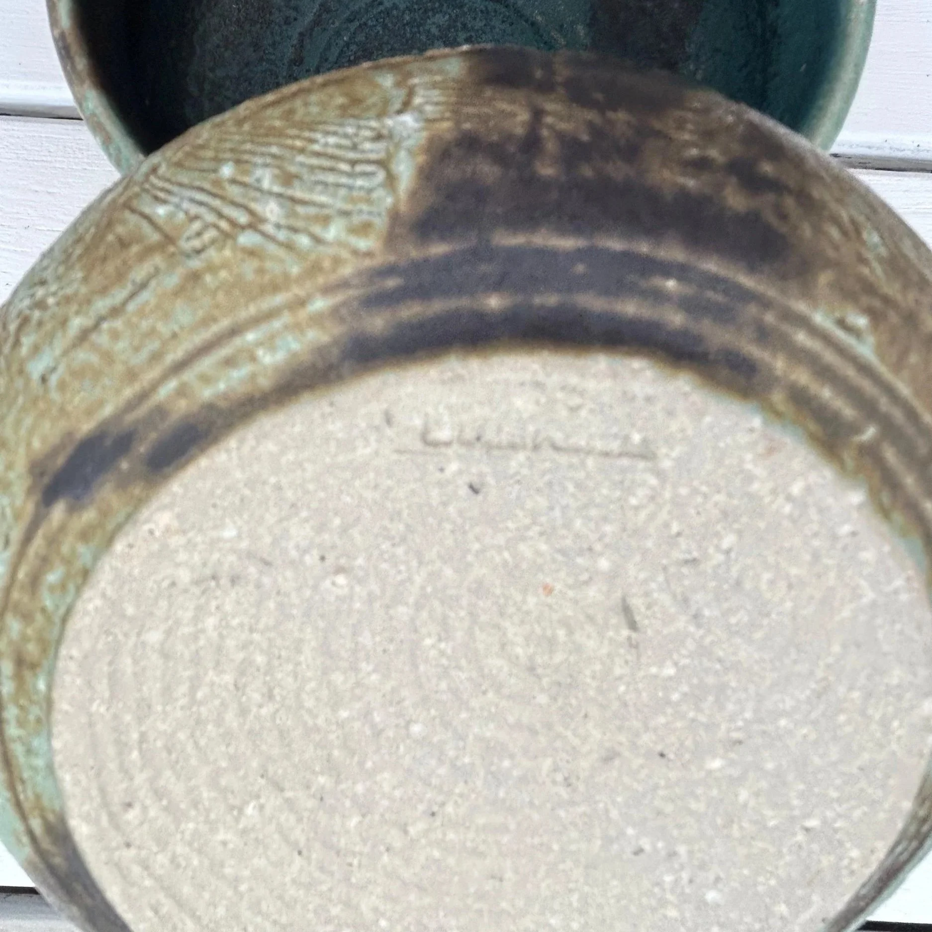 Bottom of bowl showing carved texture and artist's signature