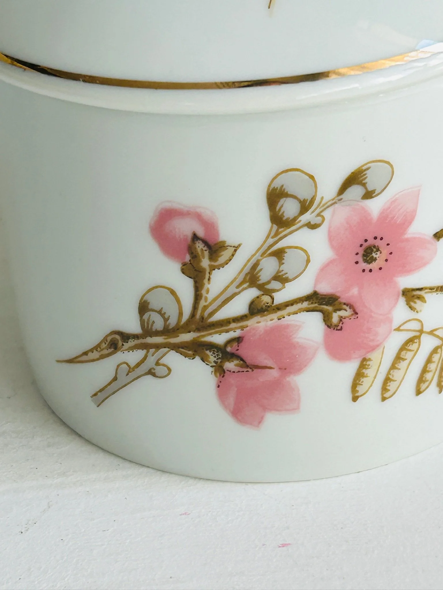 Close-up of the bowl’s side, highlighting the hand-painted pink flowers, brown branch motif, and gold accents
