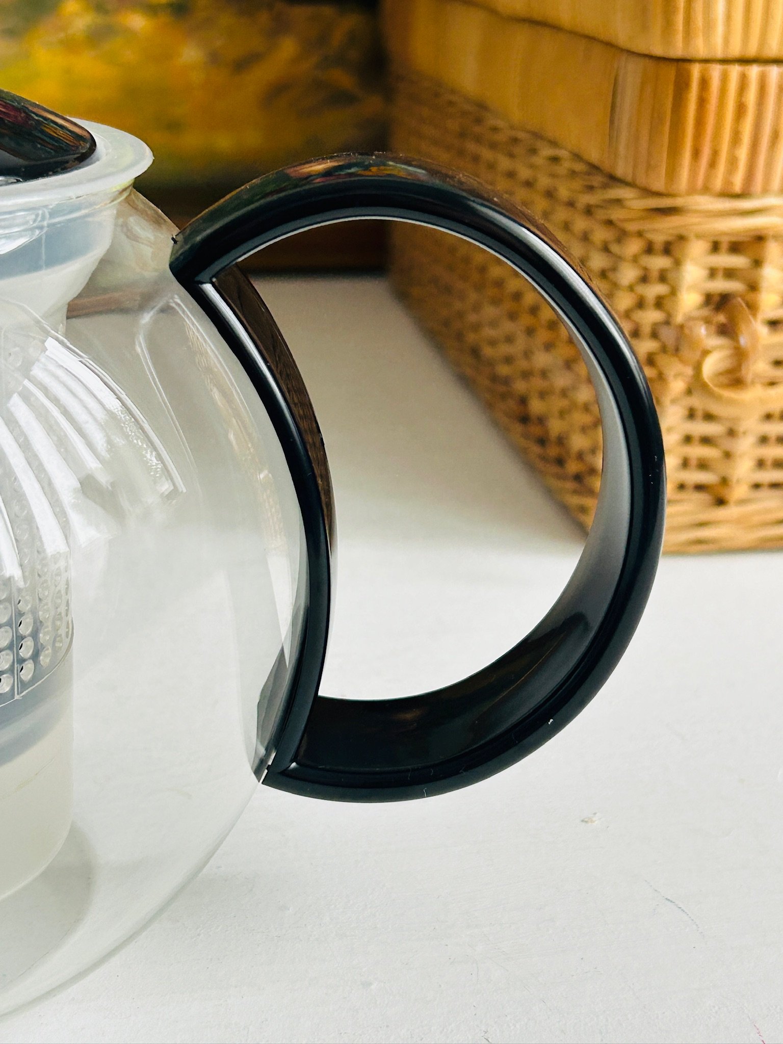 Close-up of the black lid and knob seated on the teapot, highlighting the smooth glossy finish and clean circular form.