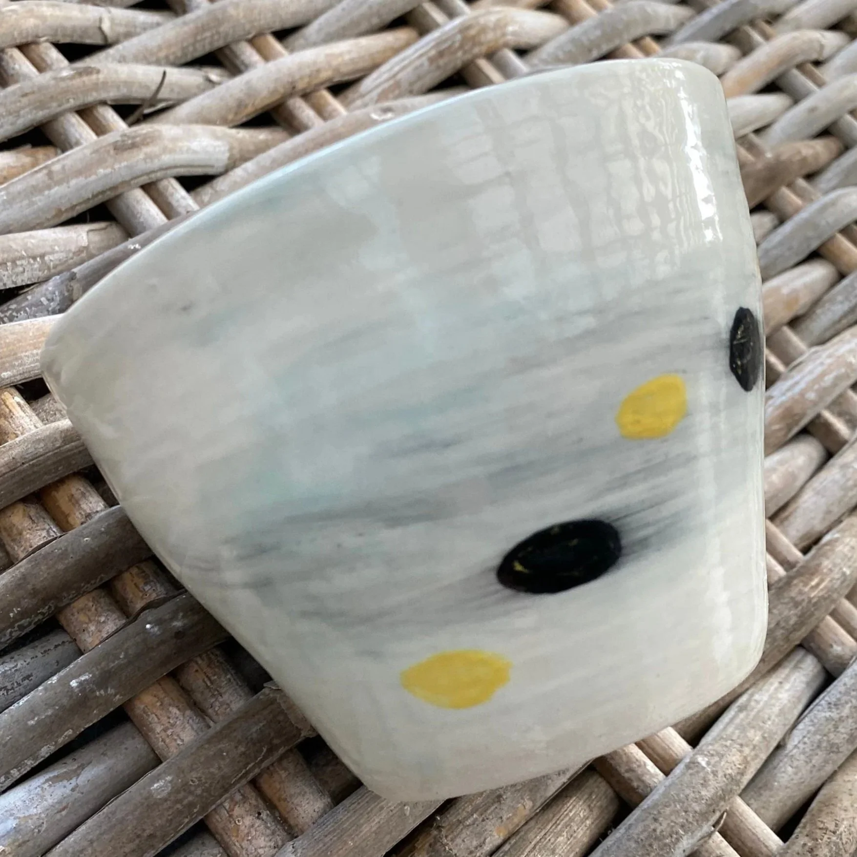 Angled profile showing glaze texture and decorative accent dots