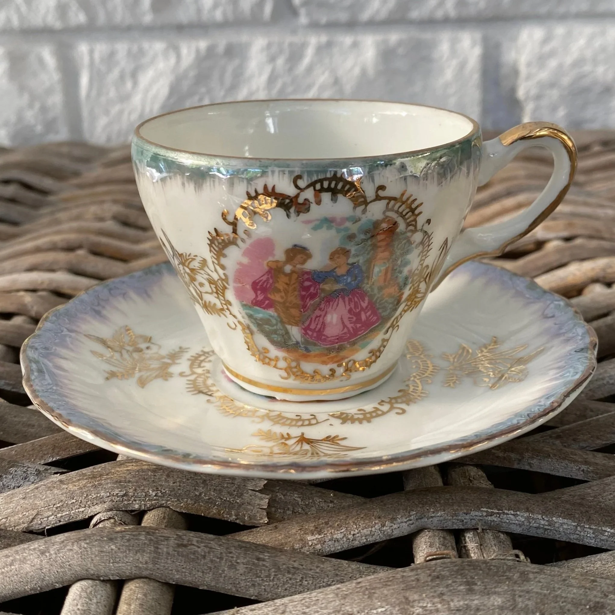 Full view of vintage lustreware teacup and saucer set showing blue rim and gold detailing