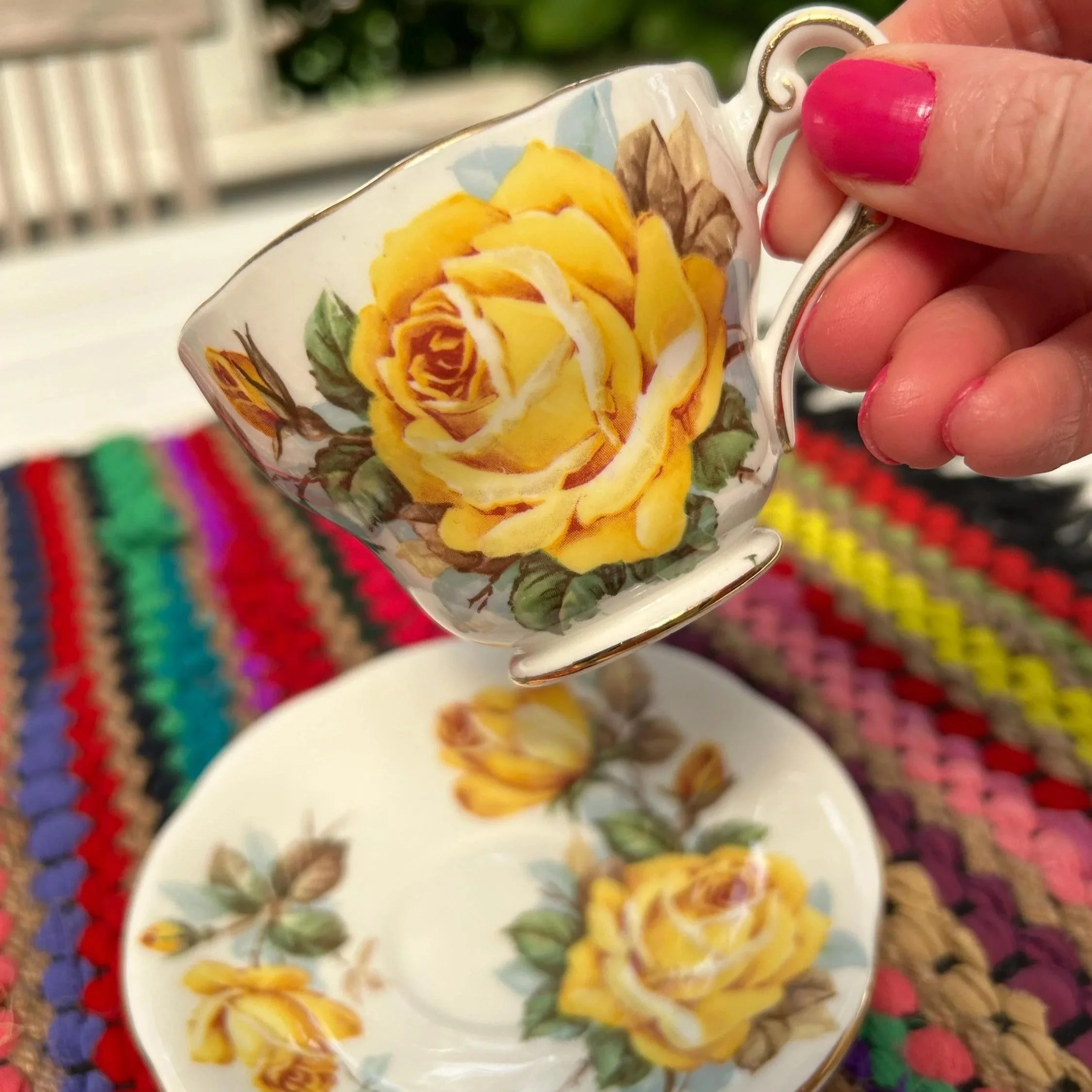 Side view of cup held by hand to show floral detail