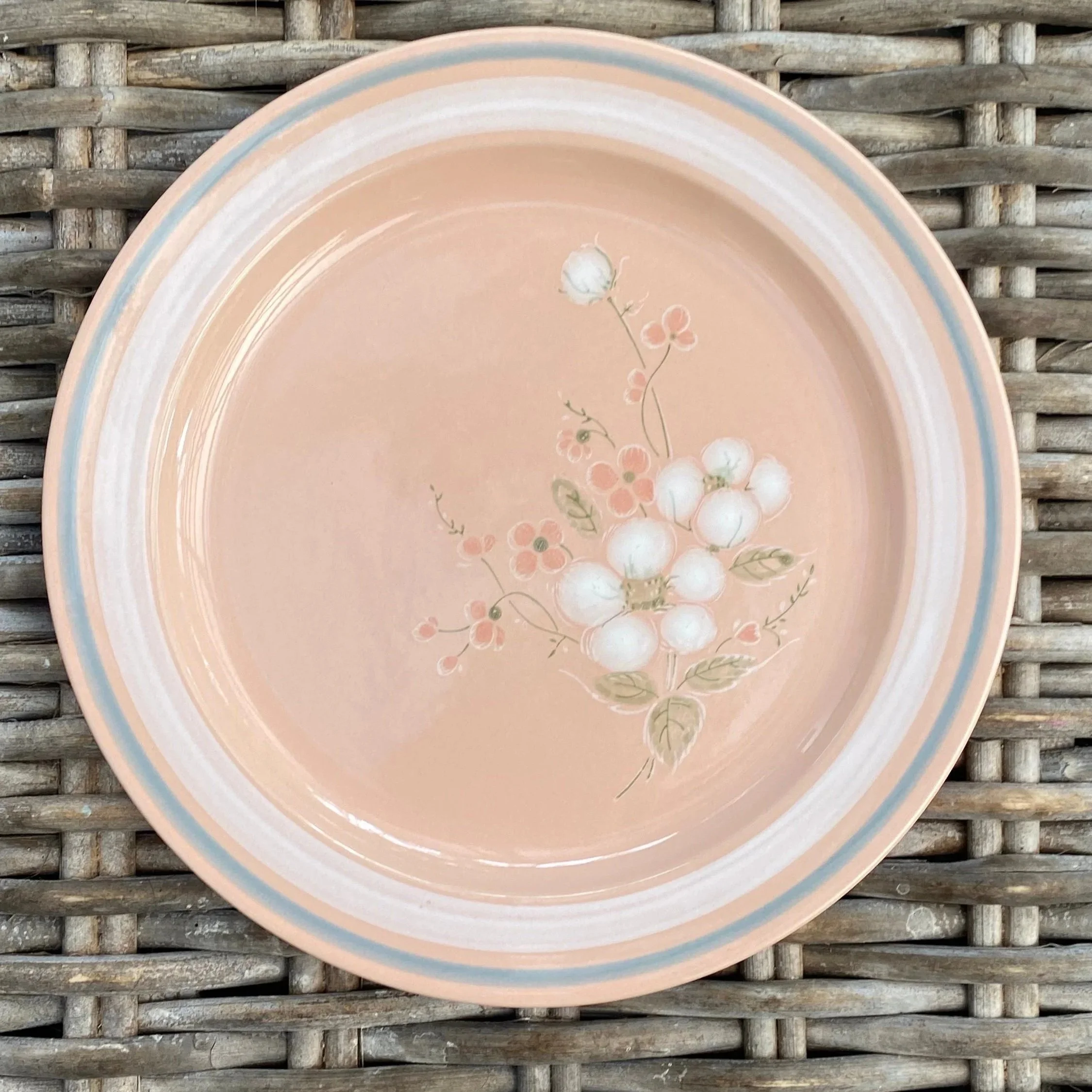 Close-up of a large dinner plate with white blossom detail
