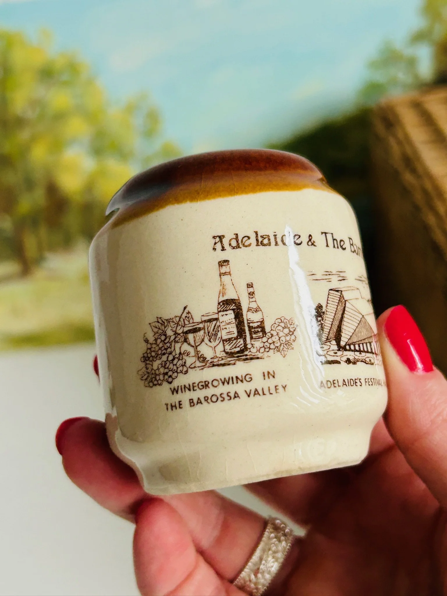 Single shaker held in hand showing the vineyard and Adelaide landmark illustrations wrapped around the body.