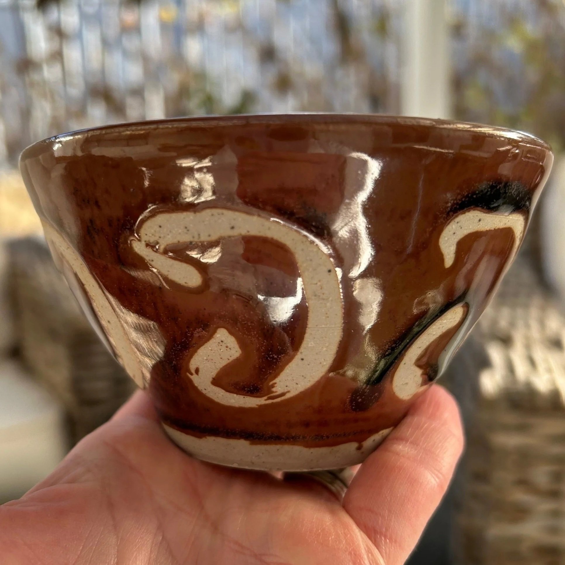 Side profile of the bowl held in hand, showing exterior design