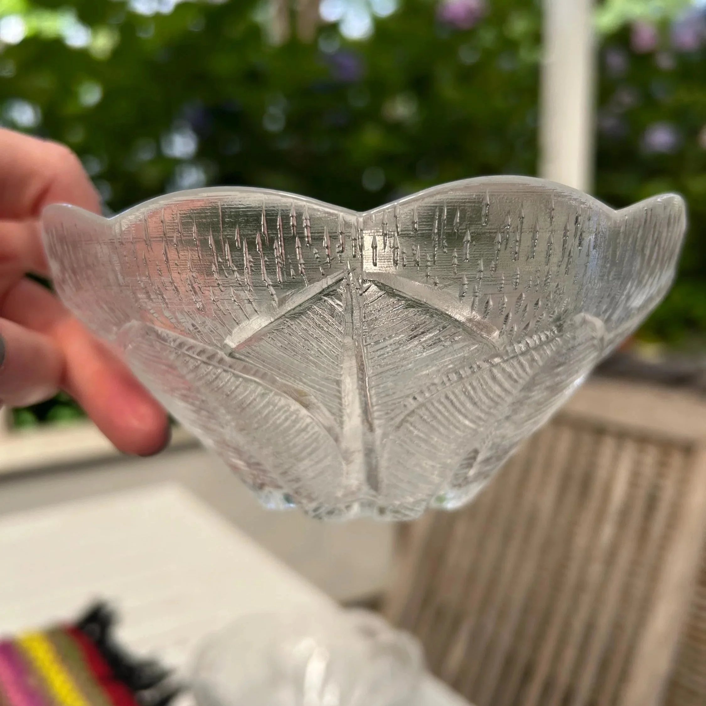 Single Violetta crystal bowl held up to show the petal-shaped rim and textured pressed glass pattern
