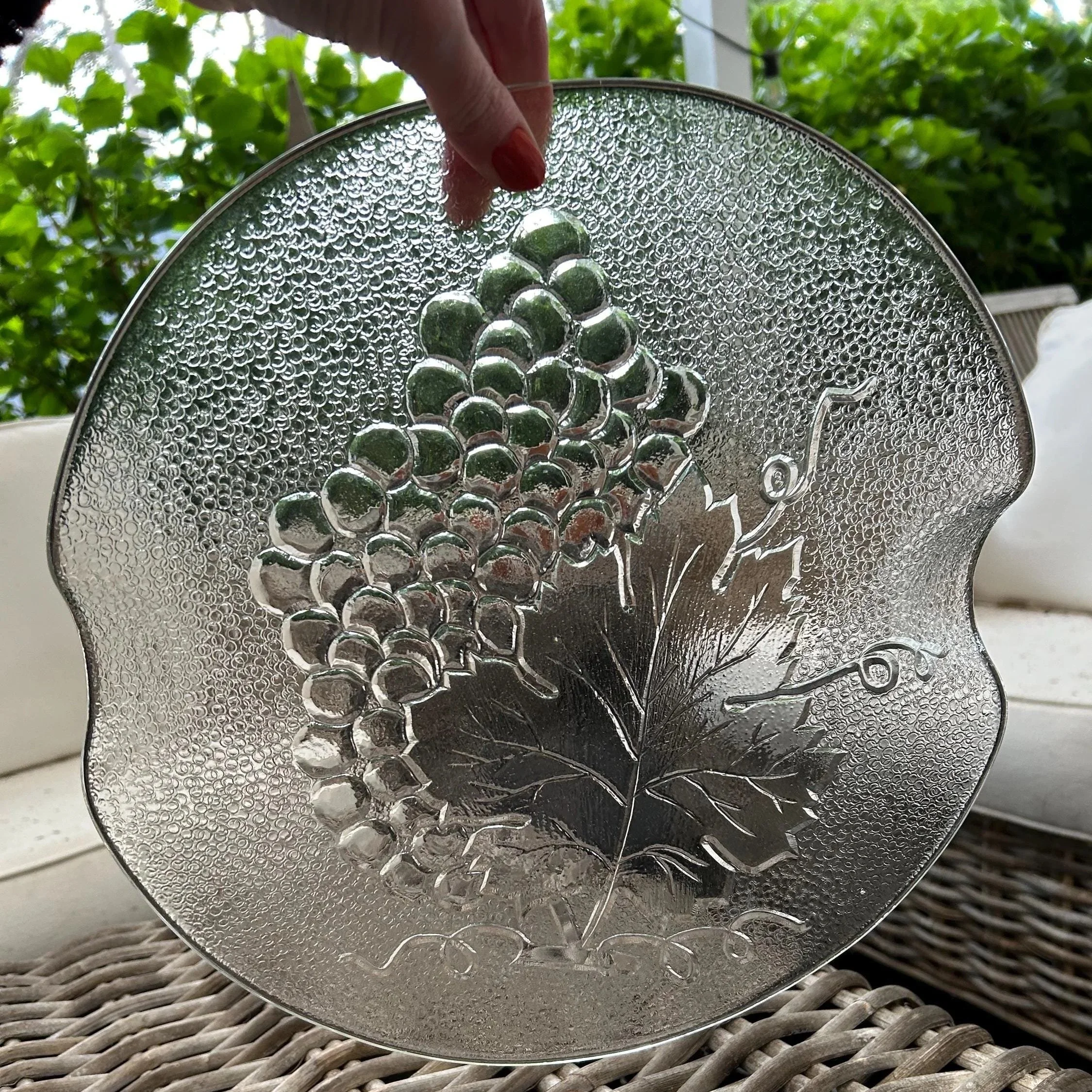 Tray held up in natural light highlighting embossed grapevine design