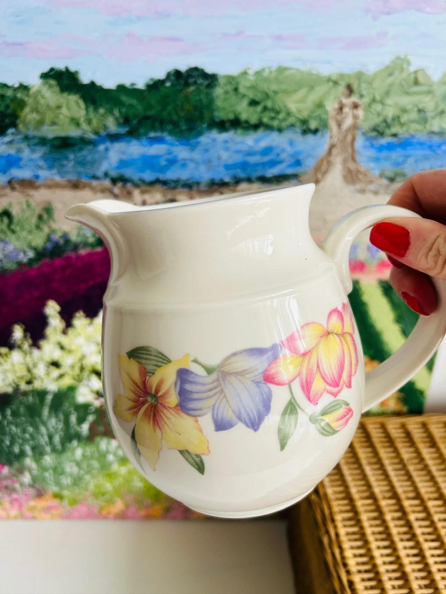 Side view of the jug held in hand showing its shape and pouring spout