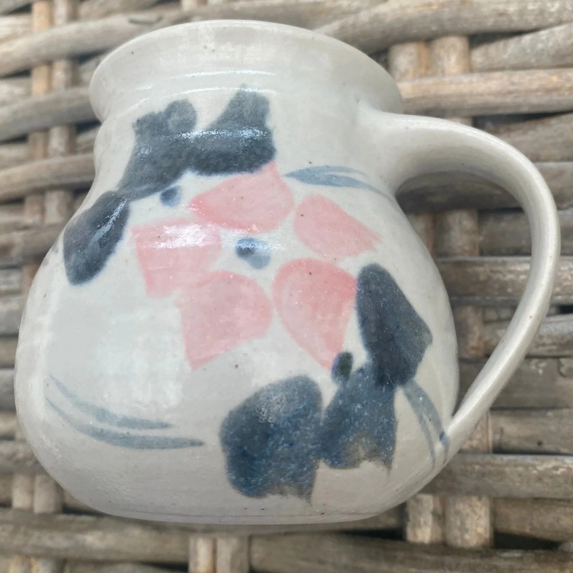 Reverse view of mug with curved handle and floral glaze detail