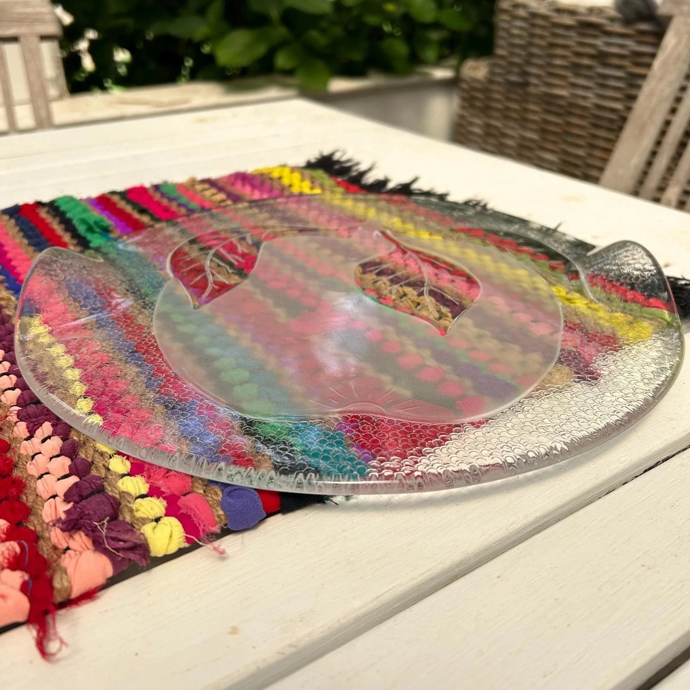 Platter resting on colourful woven mat showing full surface design.