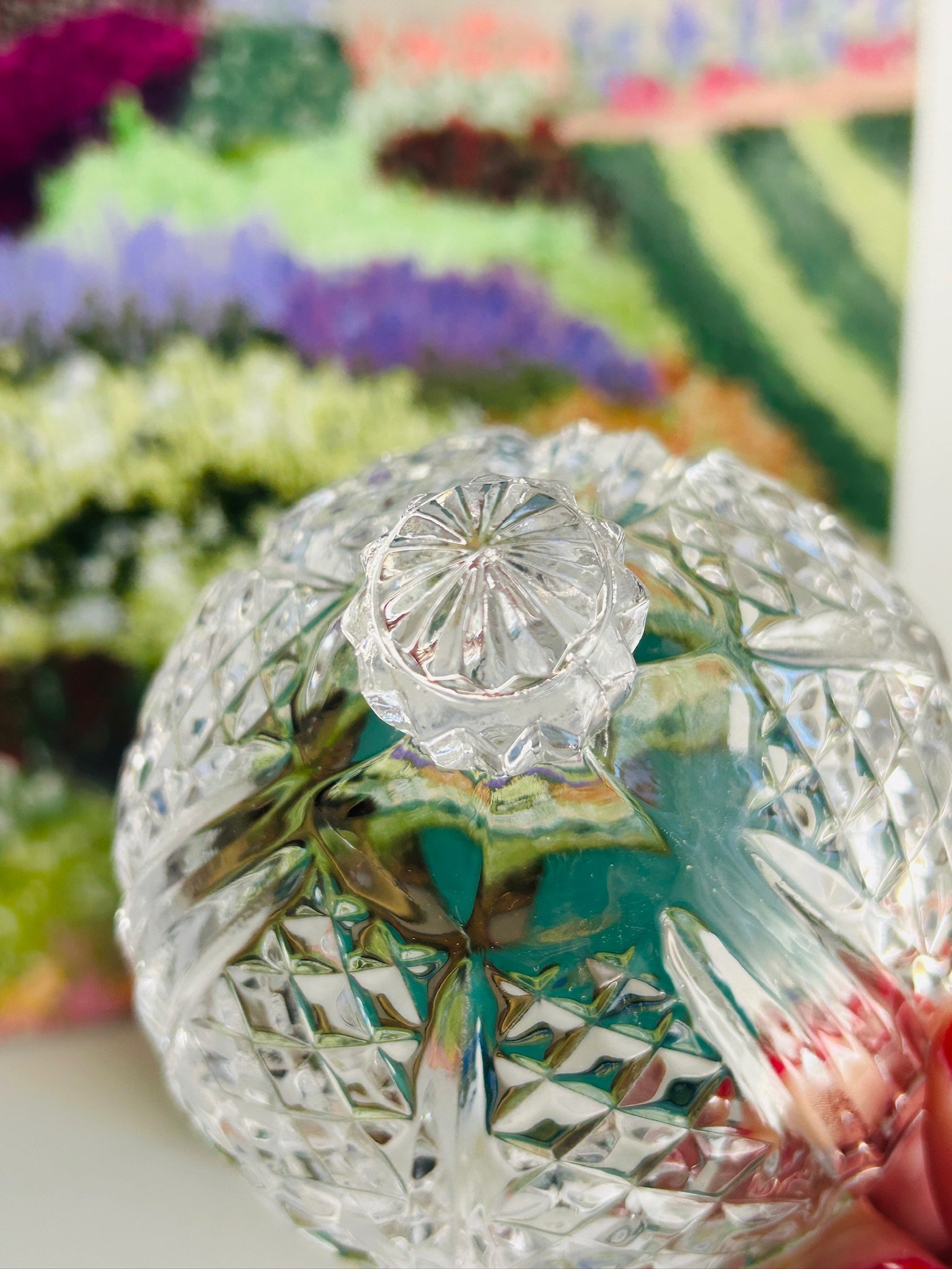 Top view of the closed lid showing the faceted finial and symmetrical cut crystal pattern across the domed surface.