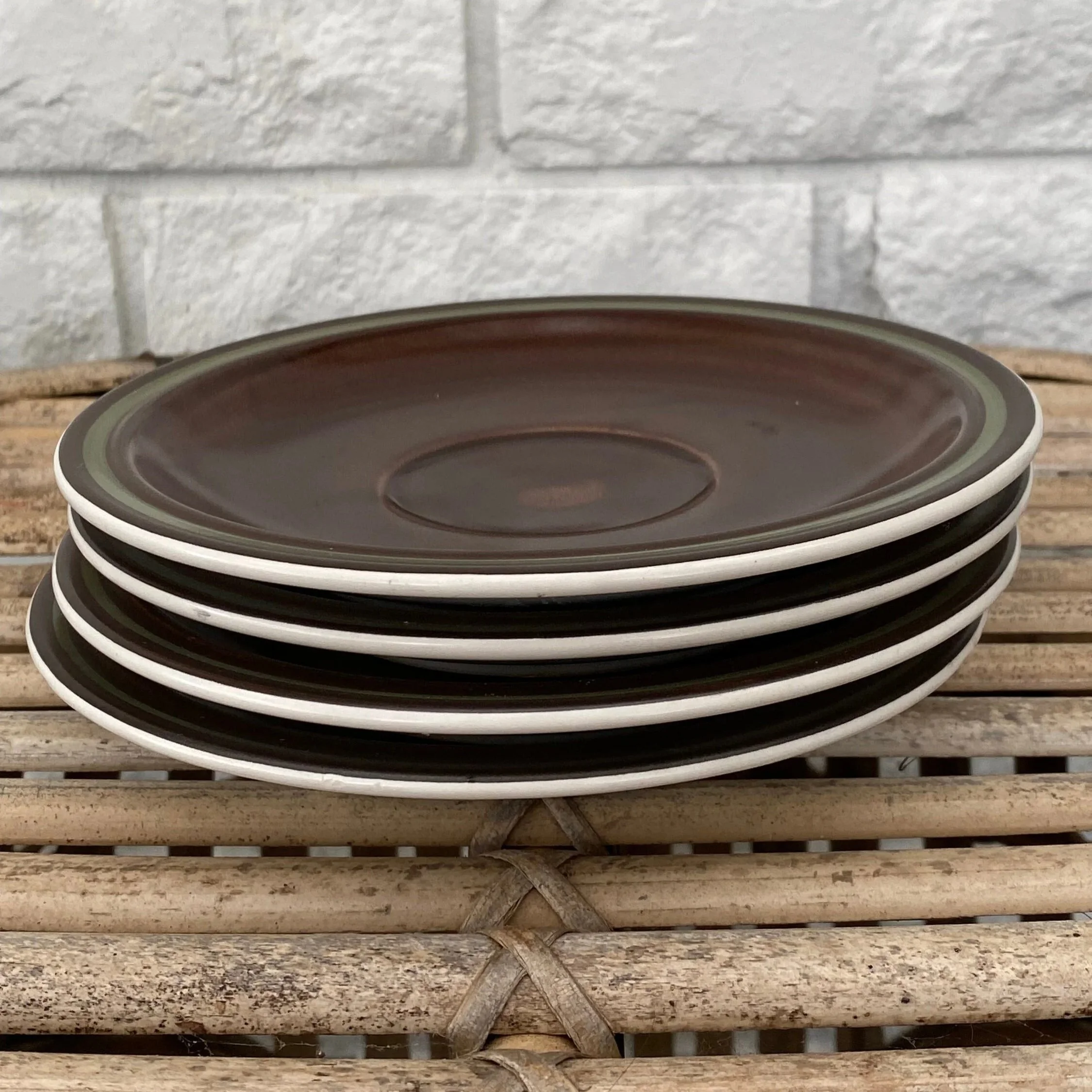 Stacked side view of all 4 saucers against neutral backdrop