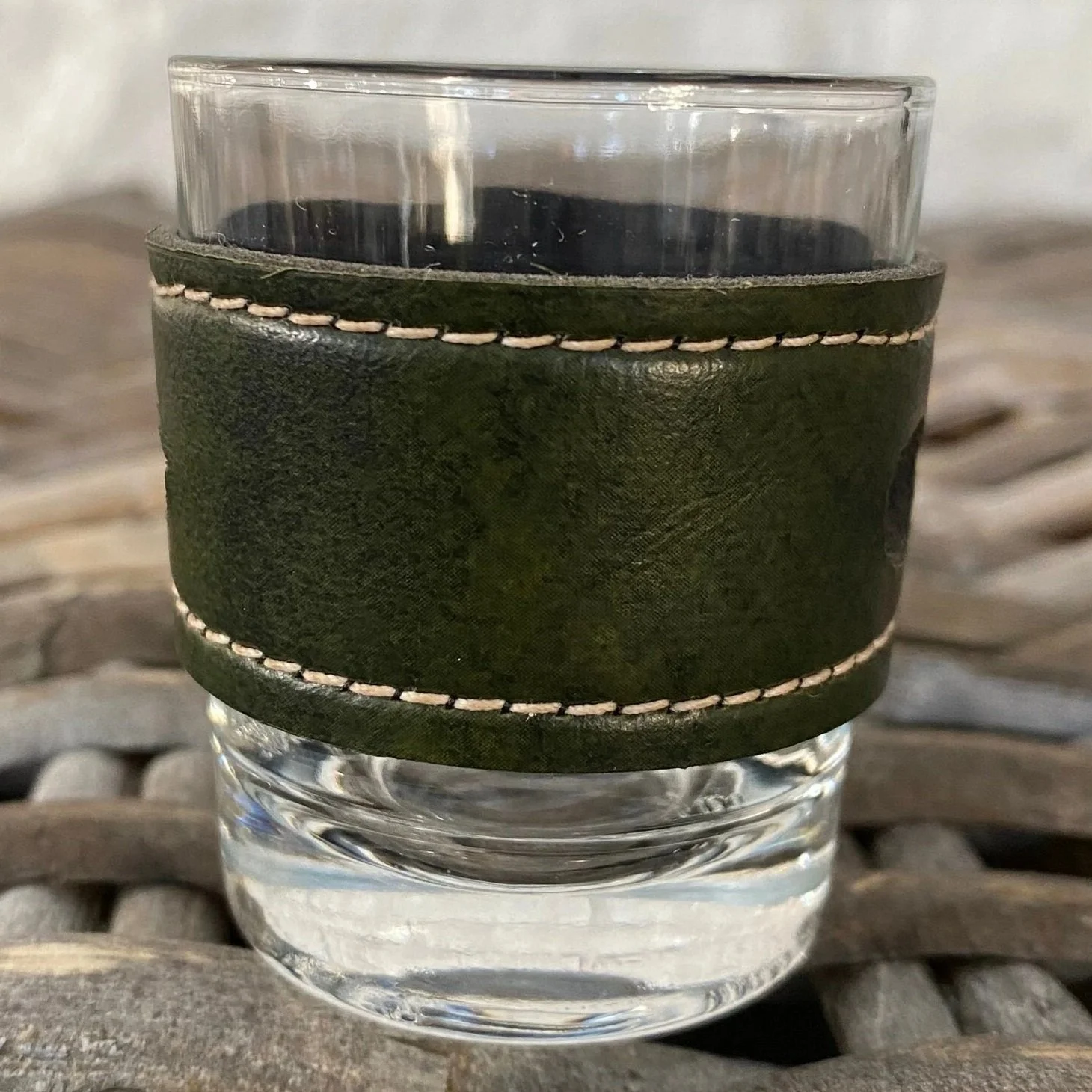 Green leather-wrapped shot glass showing texture and stitching detail