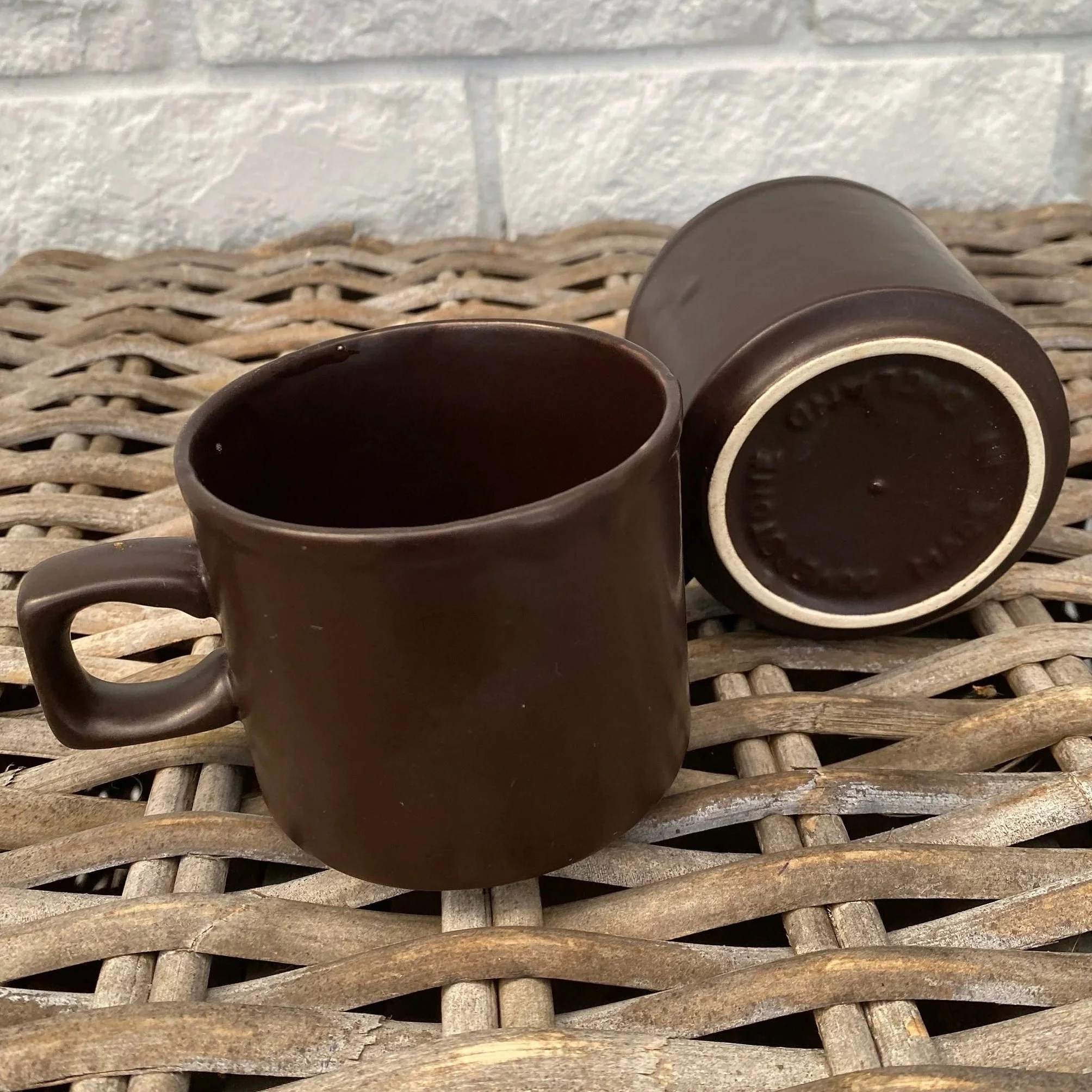 Mugs resting on table showing matte brown finish and handles