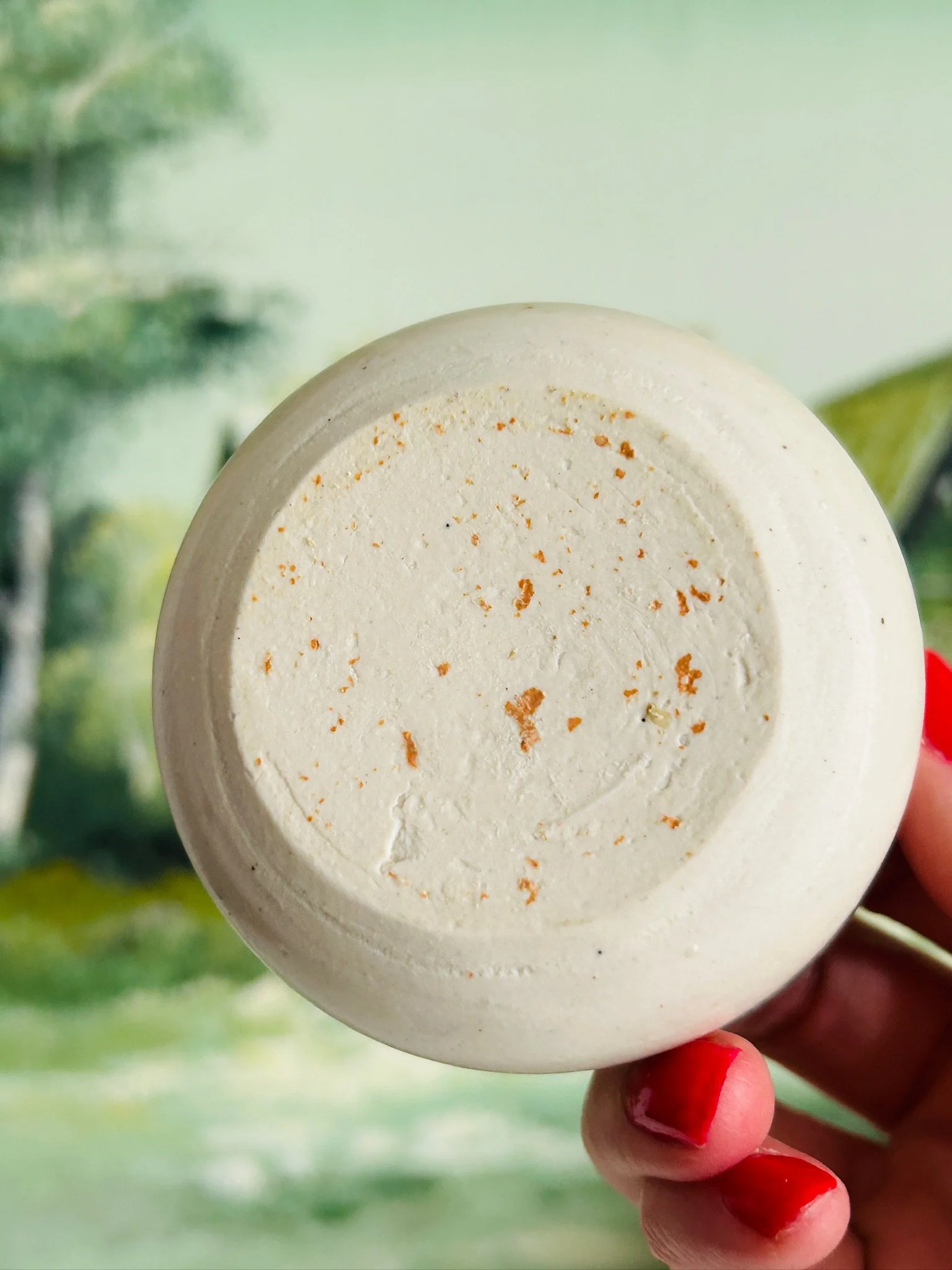 Underside of the handmade ceramic bowl showing the unglazed base with natural speckling and no visible maker’s mark