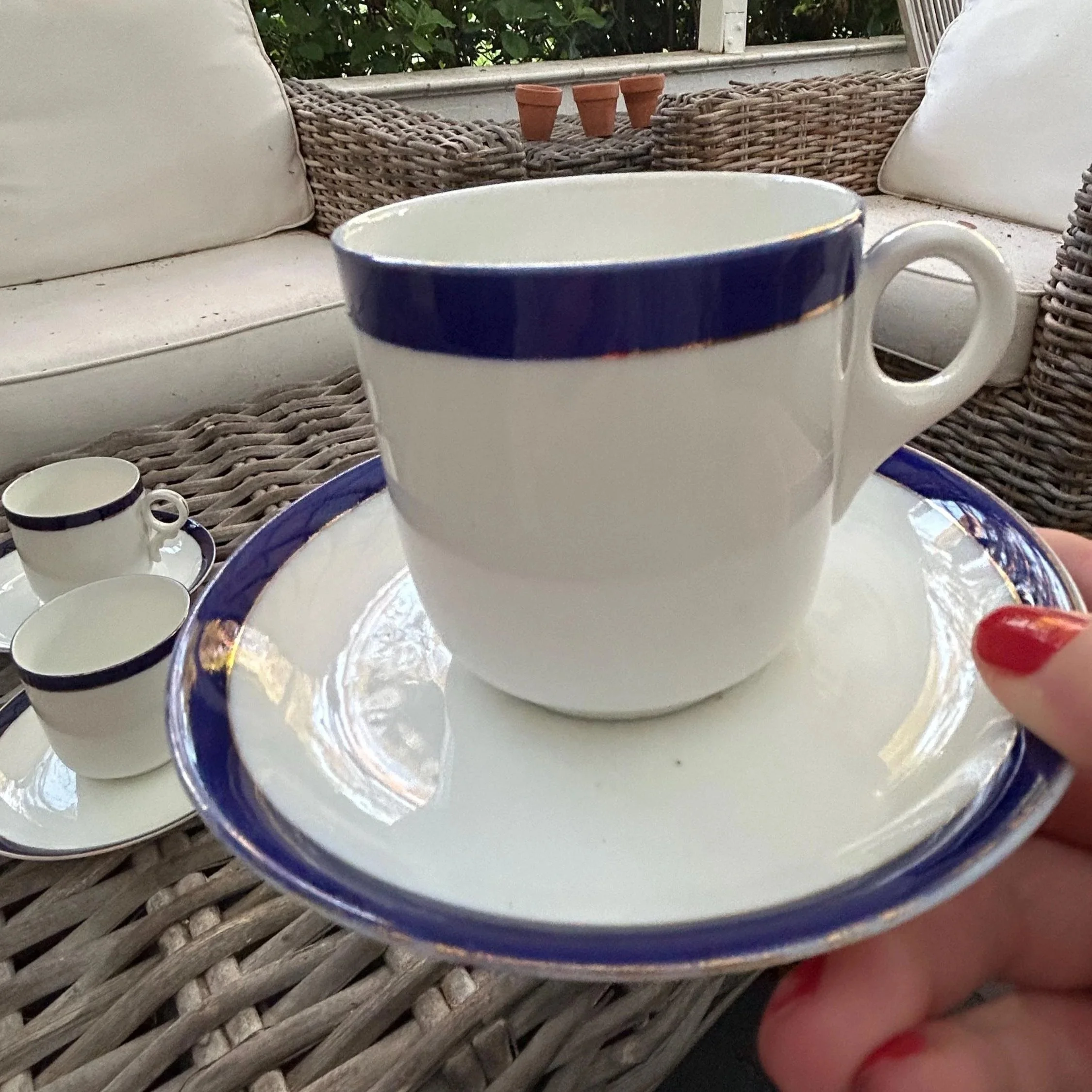 Close-up of a single cup and saucer with navy trim and gilt edge