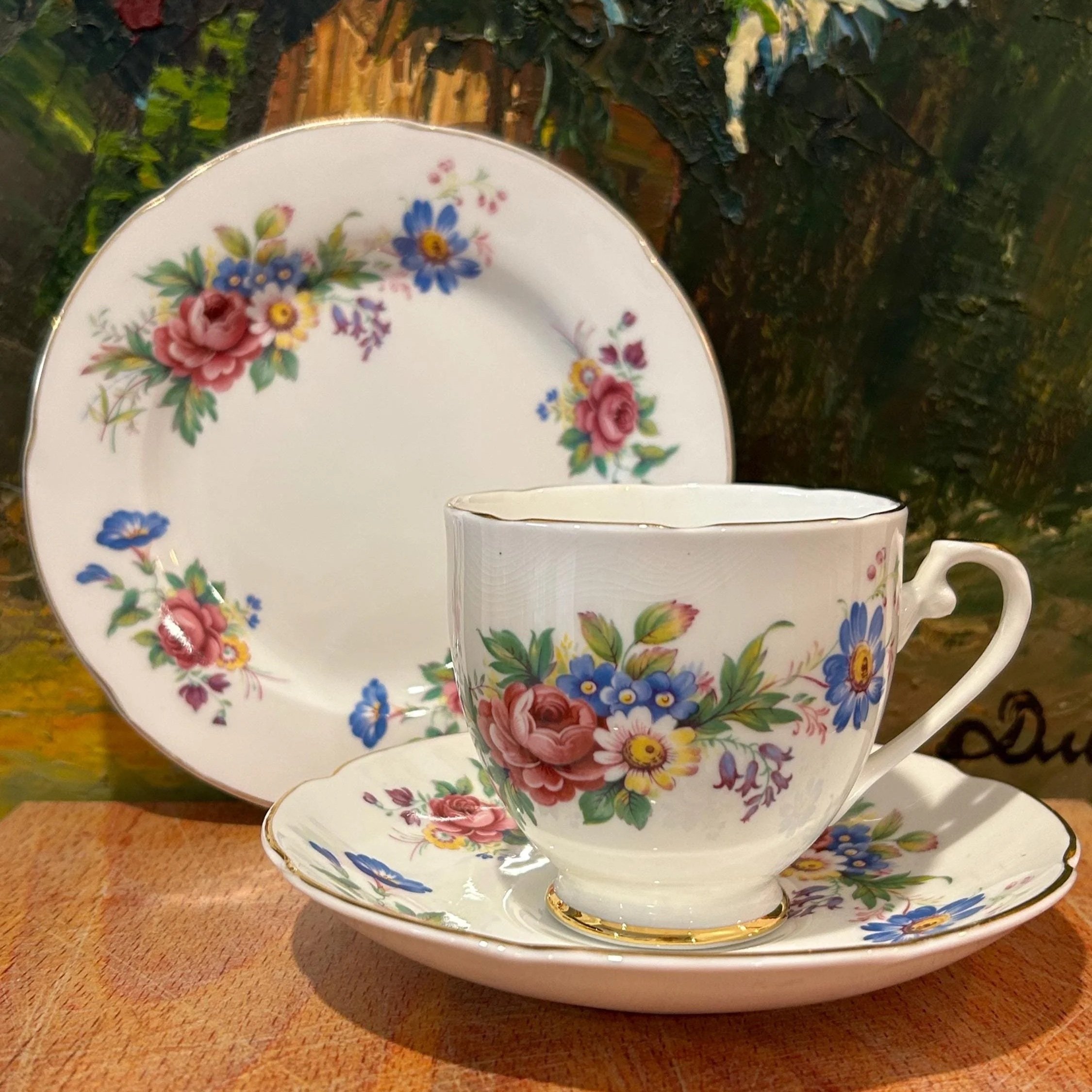 Teacup in front of saucer and plate showing floral alignment