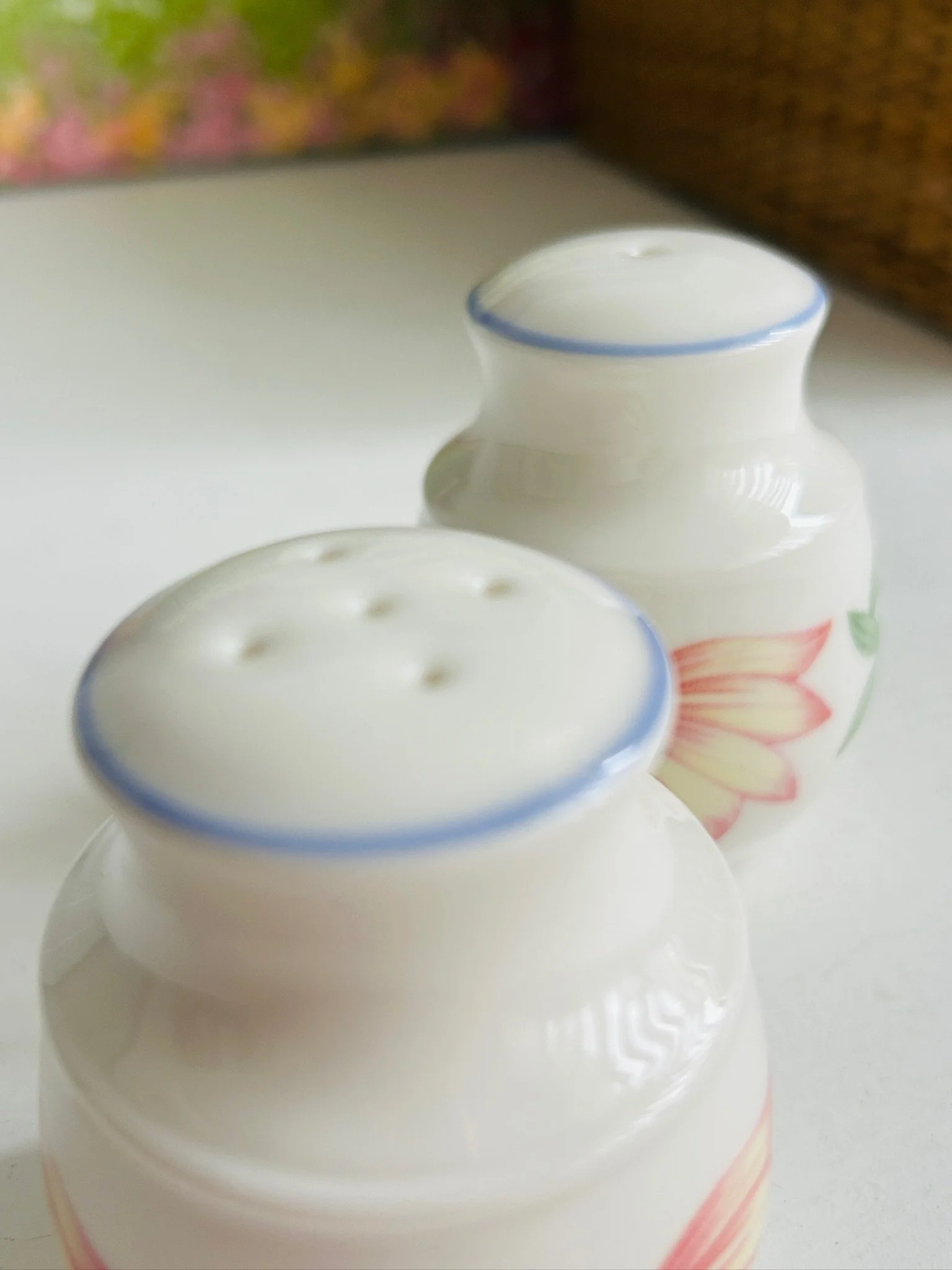 Front view of both shakers side by side, showing the matching shape and pastel floral decoration