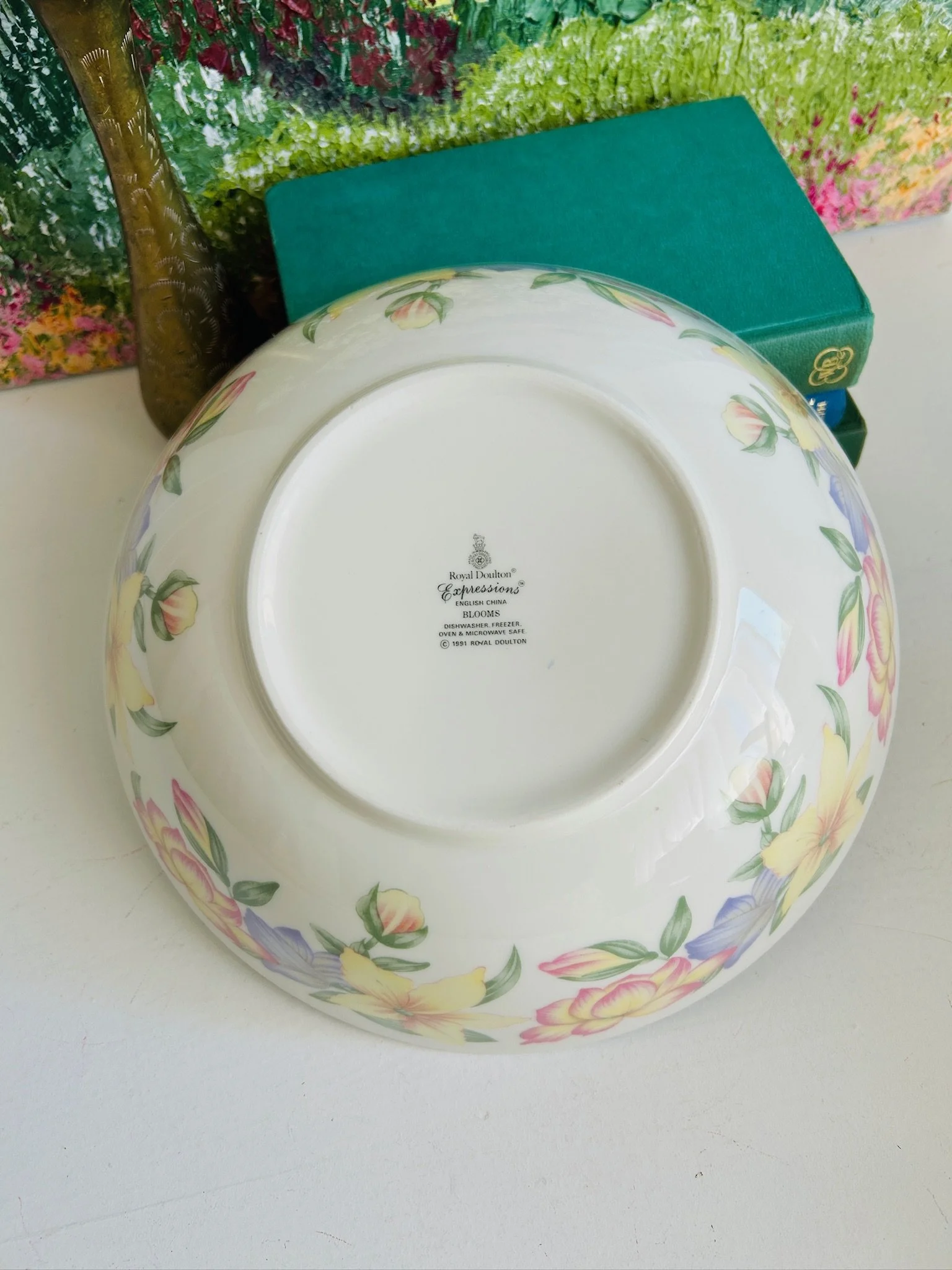 Base view of the large serving bowl, showing the footed underside and floral decoration wrapping around the outer edge