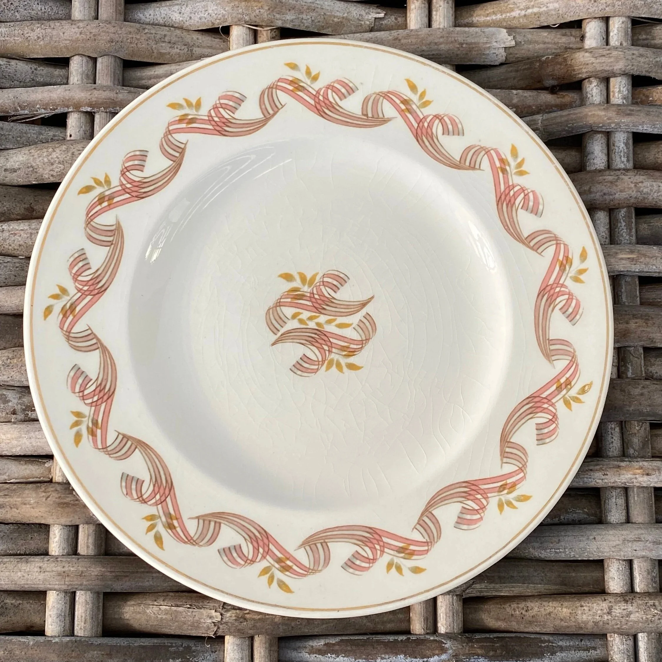 Close-up of one Empire England Symphony plate with floral scroll border