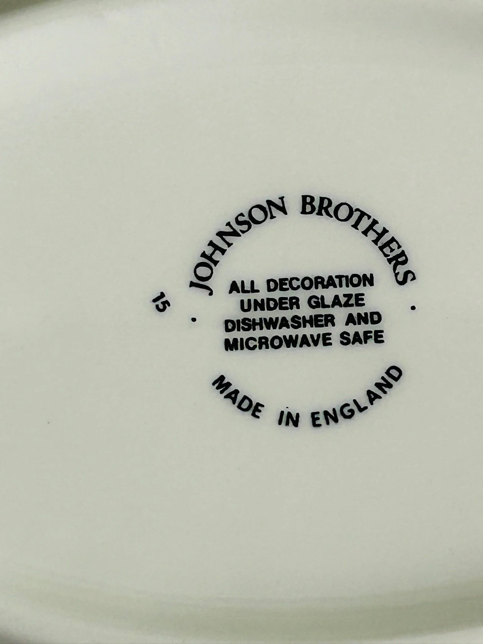 Close-up of the Johnson Brothers backstamp on the underside, reading all decoration under glaze, dishwasher and microwave safe, made in England.