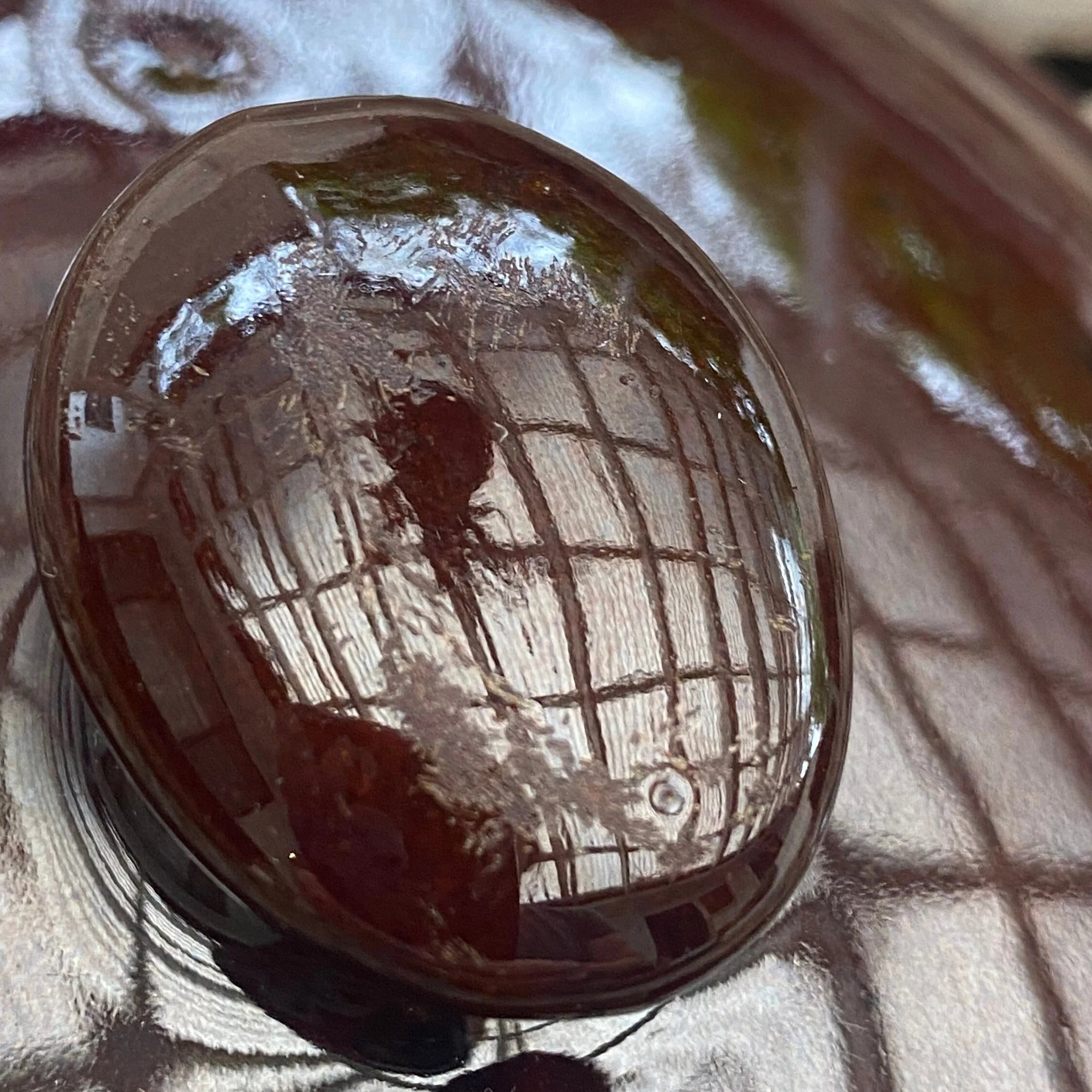 Close-up of the glossy brown lid surface with visible vintage wear and reflections