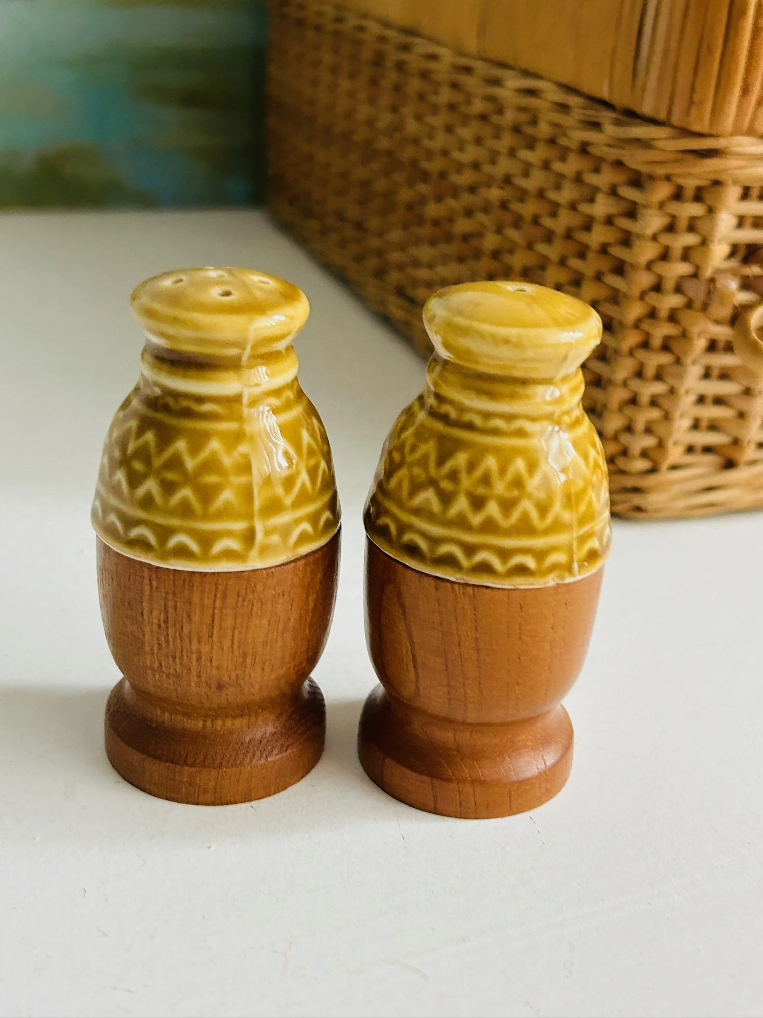 Both salt and pepper shakers displayed together on a white surface with basket background