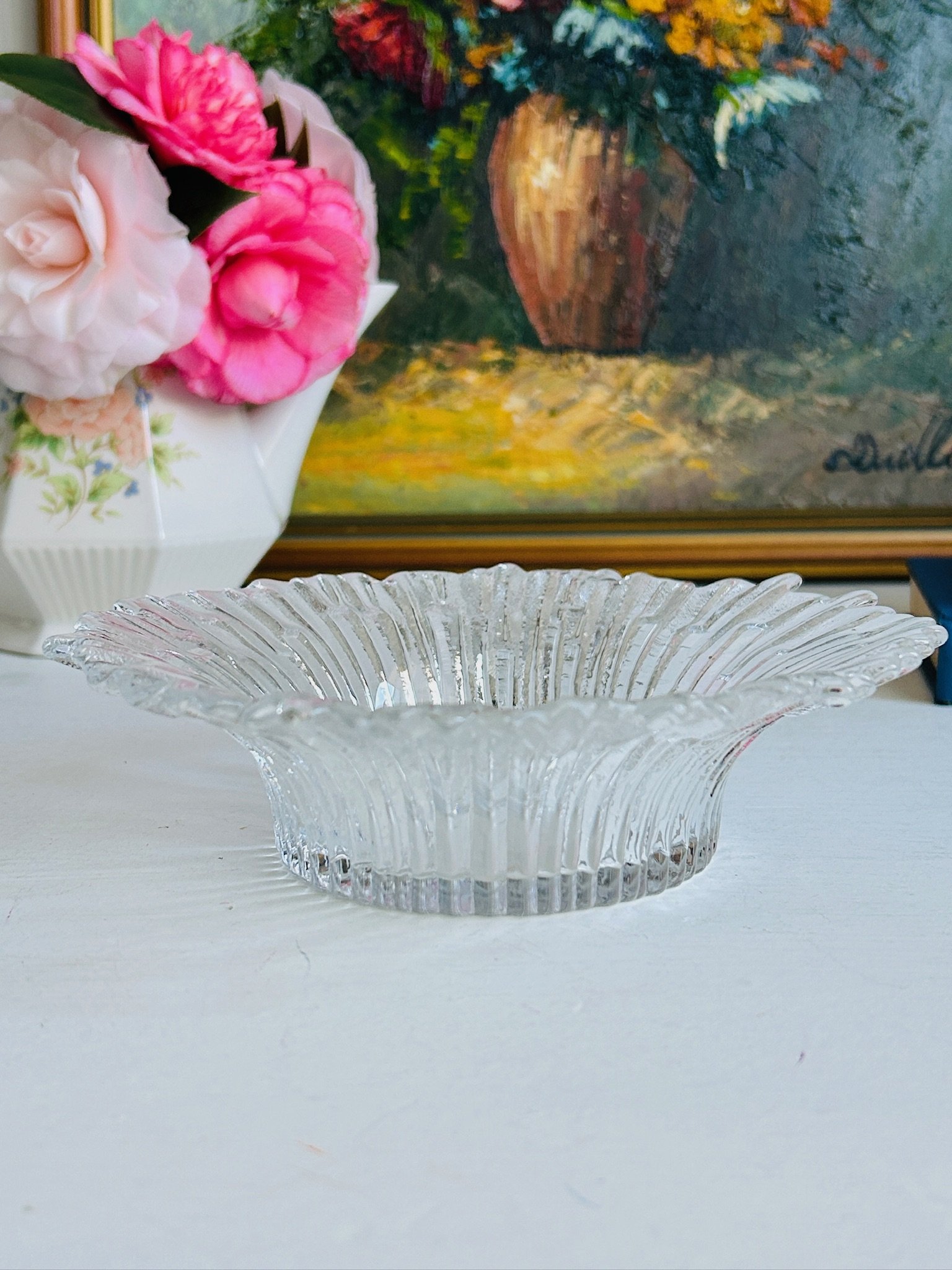 Vintage Humppila Revontulet glass dish displayed on blue books beside a white floral jug, side profile