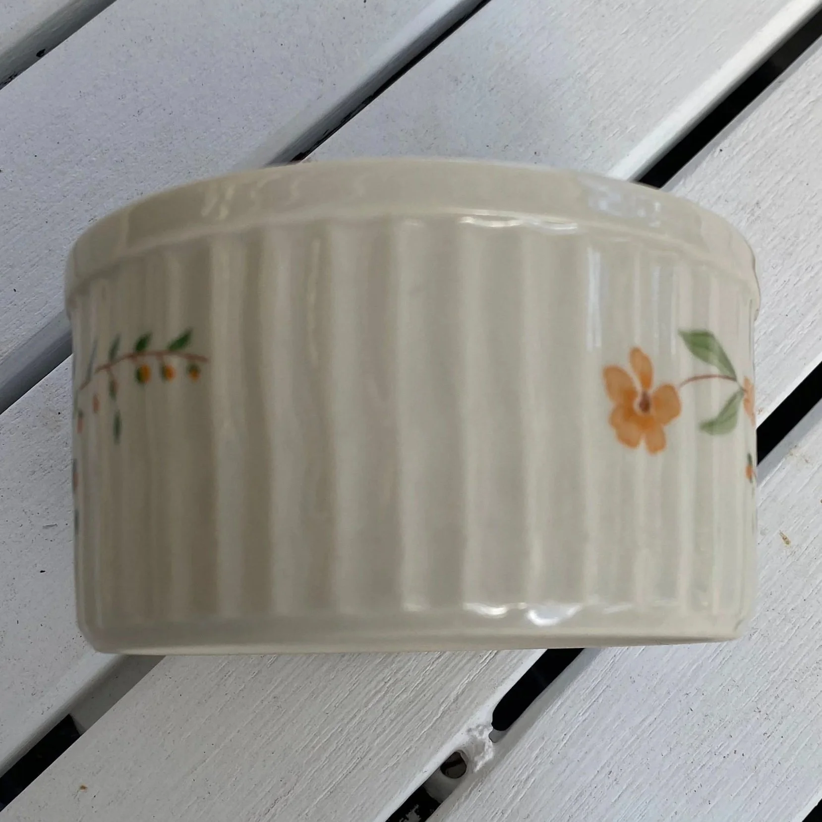 Side view showing floral vine detail on cream stoneware