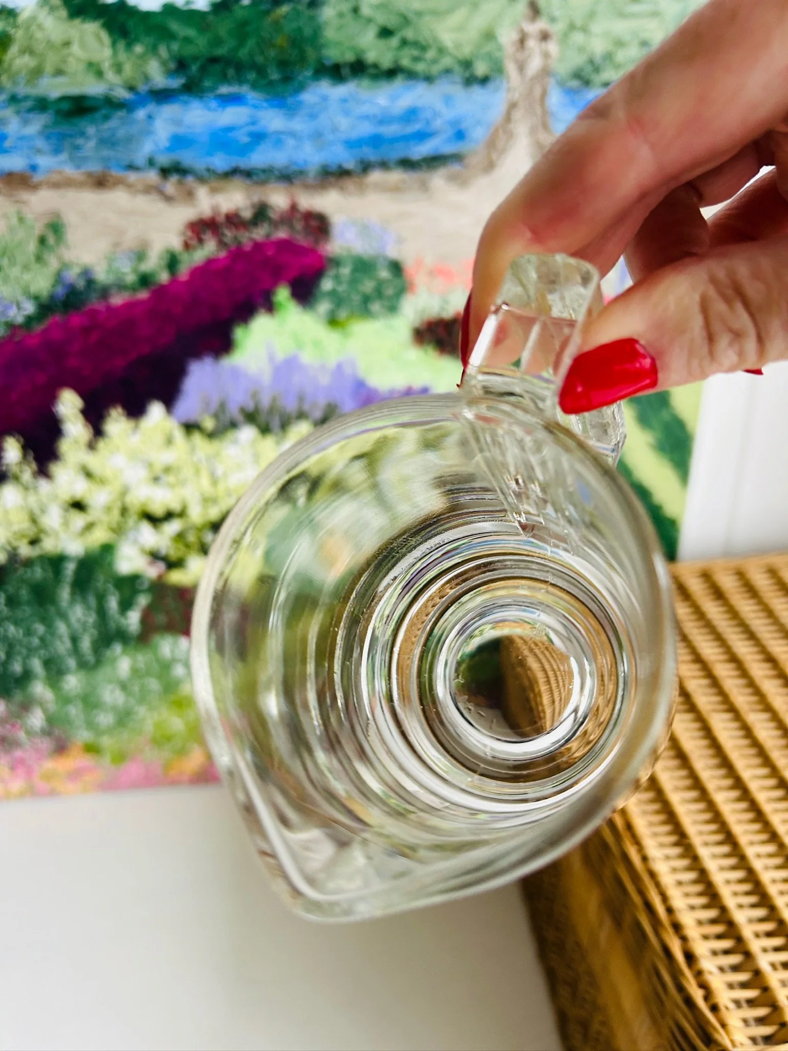Top-down view into the vintage glass creamer, showing the circular interior opening, pouring lip, and handle attachment