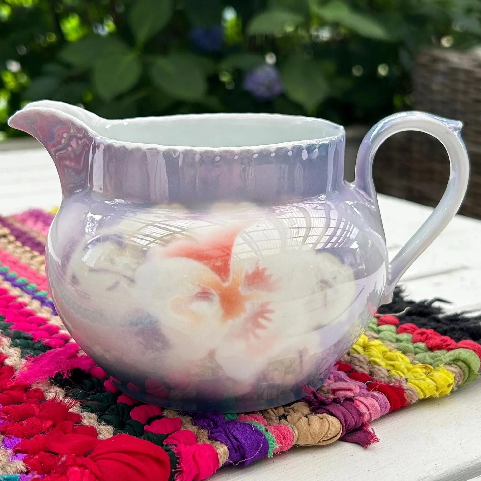 Side view of Victoria China creamer with lavender lustre glaze and hand-painted floral motif