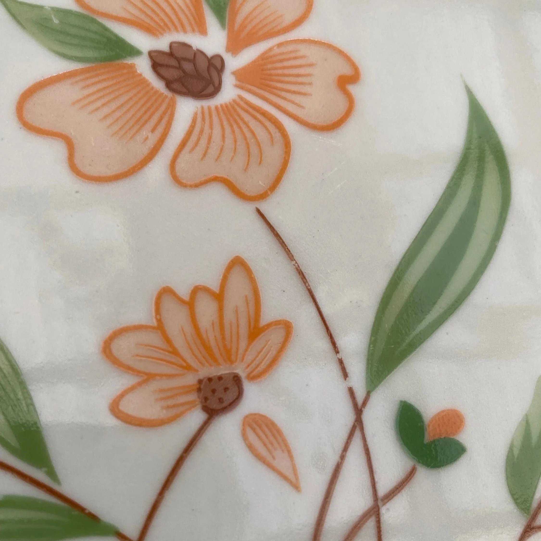 Close-up of floral motif detail with orange flowers and green foliage