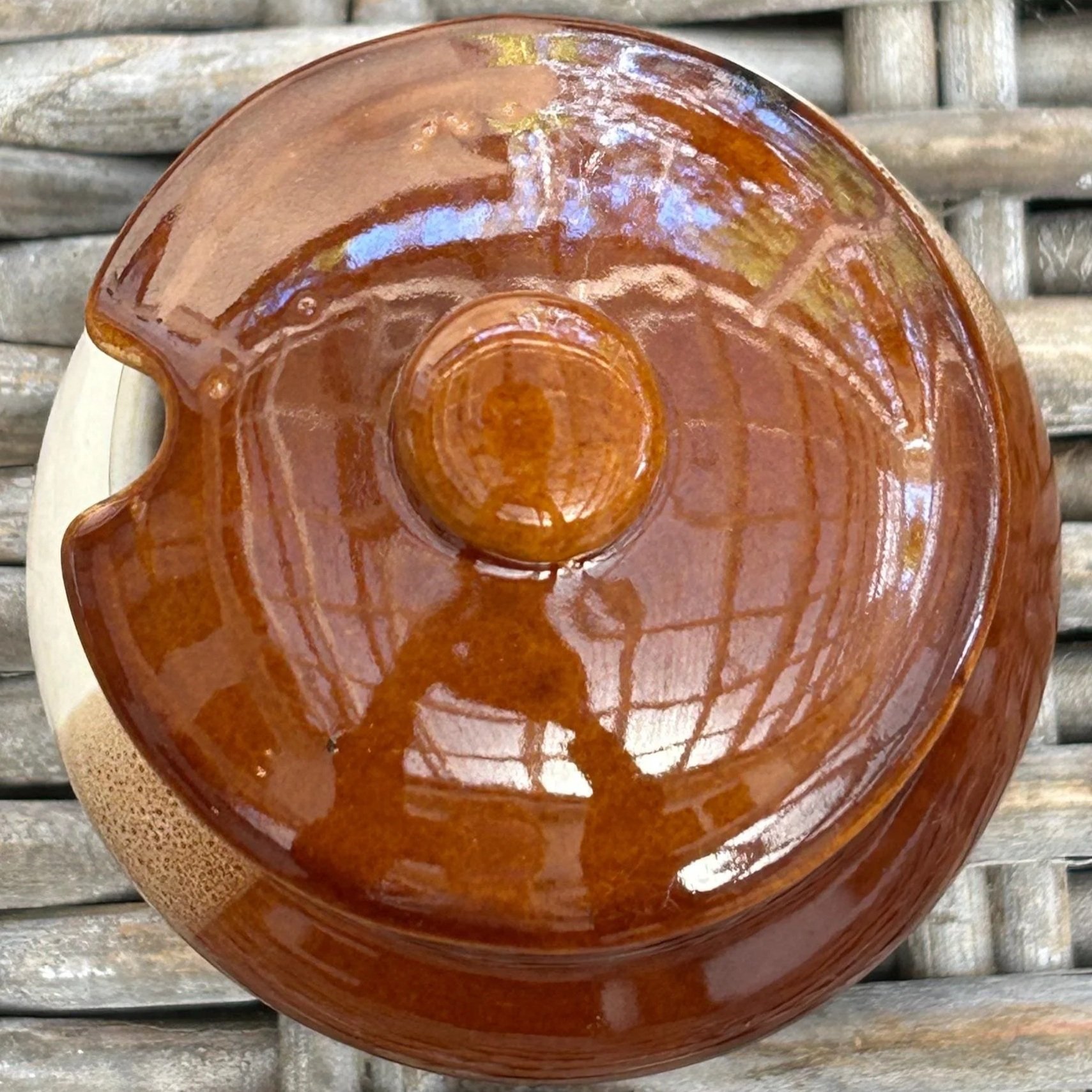 Top view of glossy brown lid with knob handle