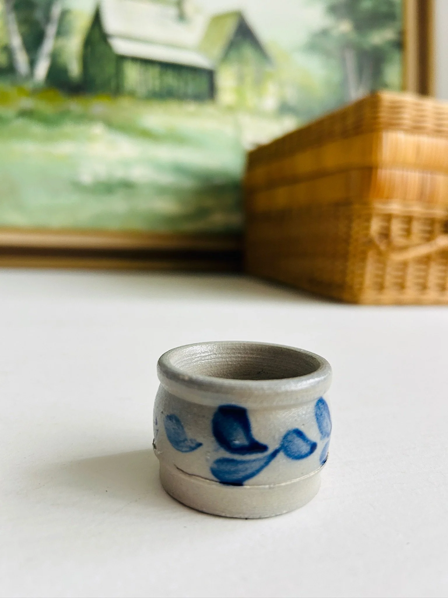 Three-quarter front view of the small blue leaf salt cellar on a white surface, showing its compact scale and rustic finish