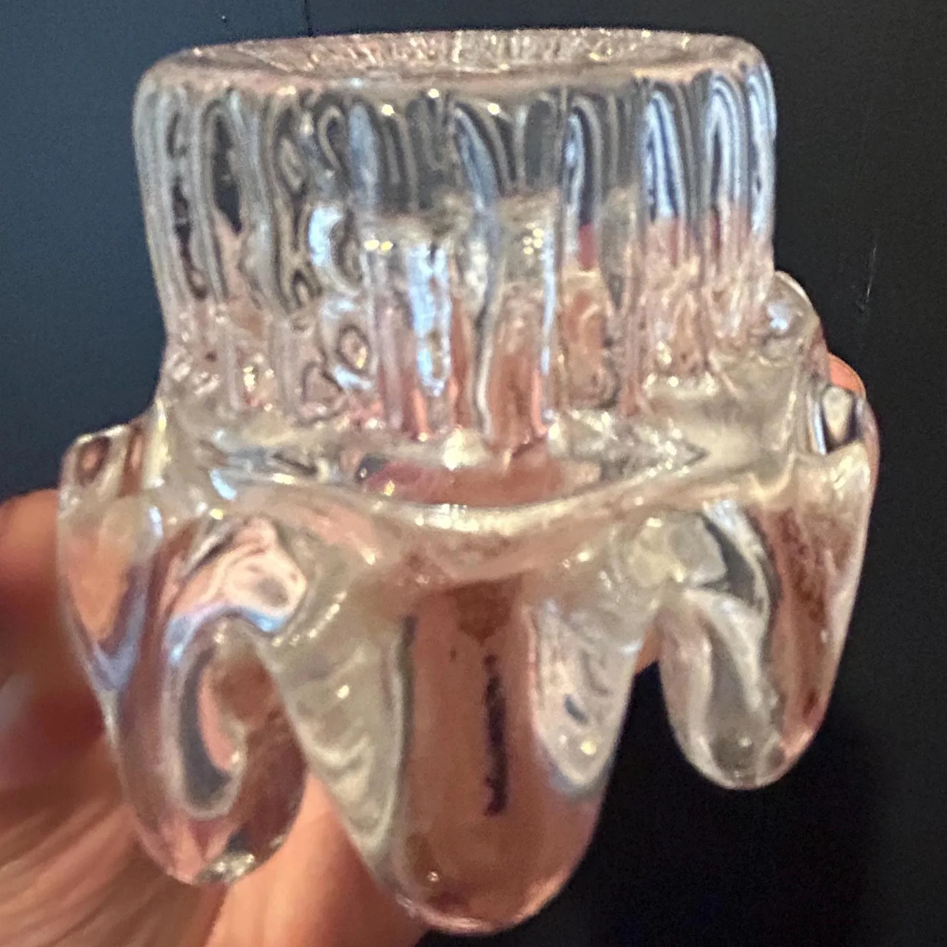 Candle holder viewed from side on dark background