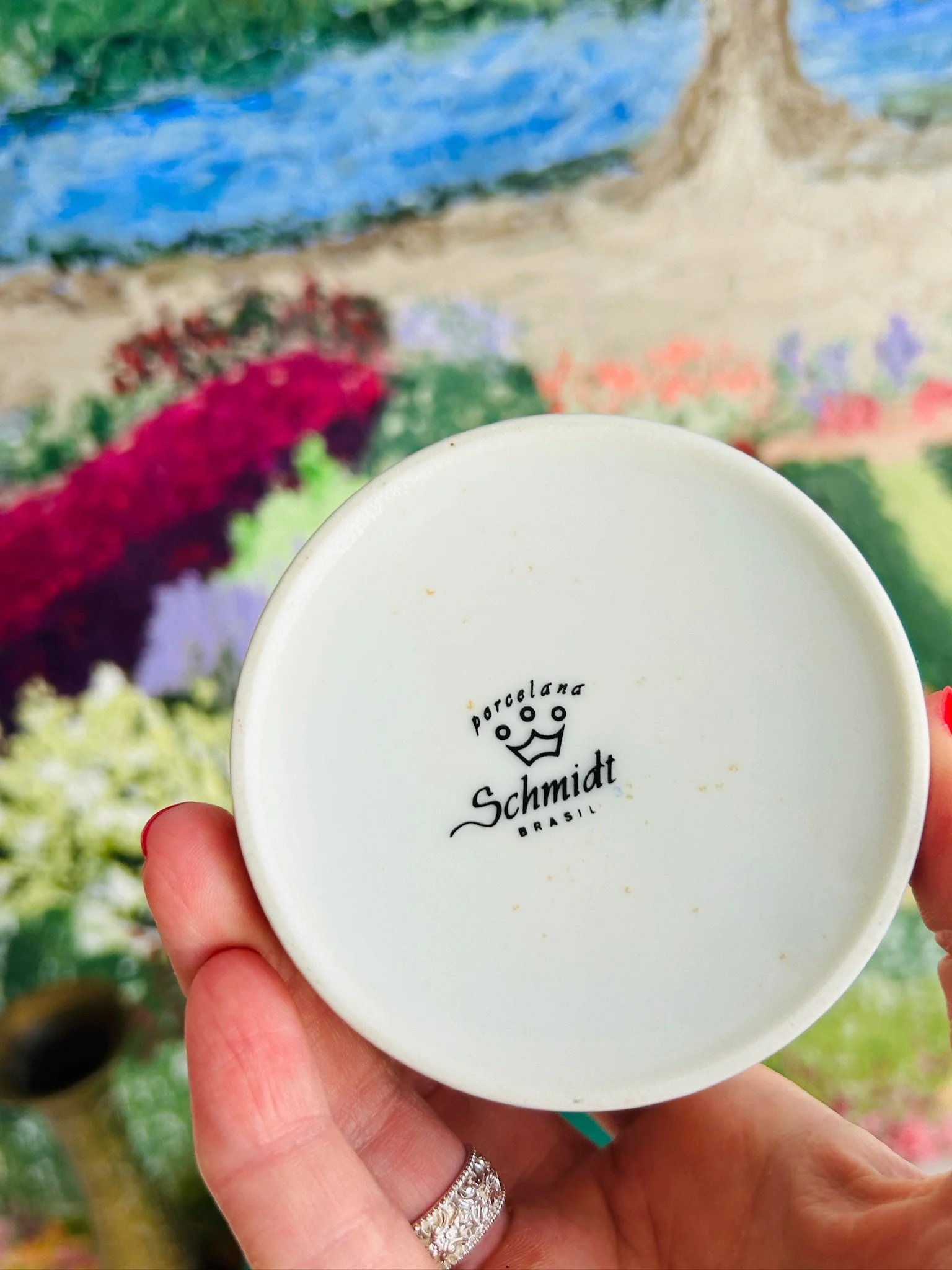 Base of the trinket bowl held in hand, showing the Porcelana Schmidt maker’s mark and light age-related speckling on the underside