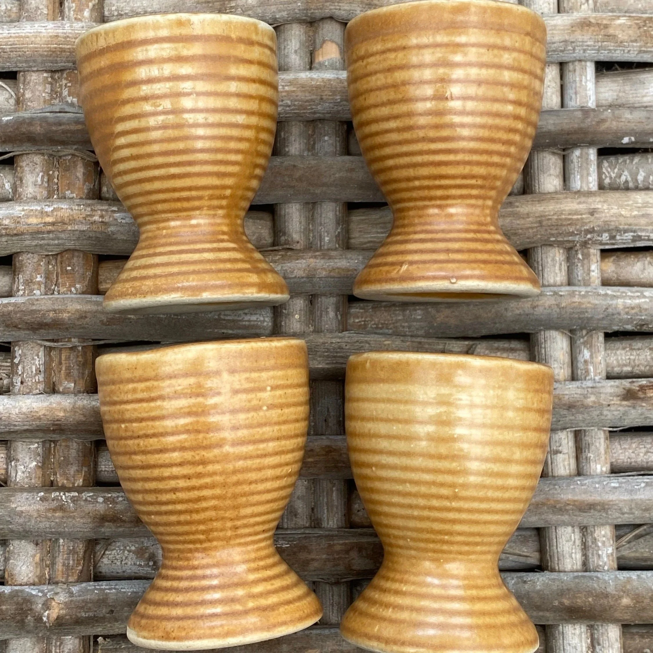 Front and side view of four Sundowner ribbed brown egg cups