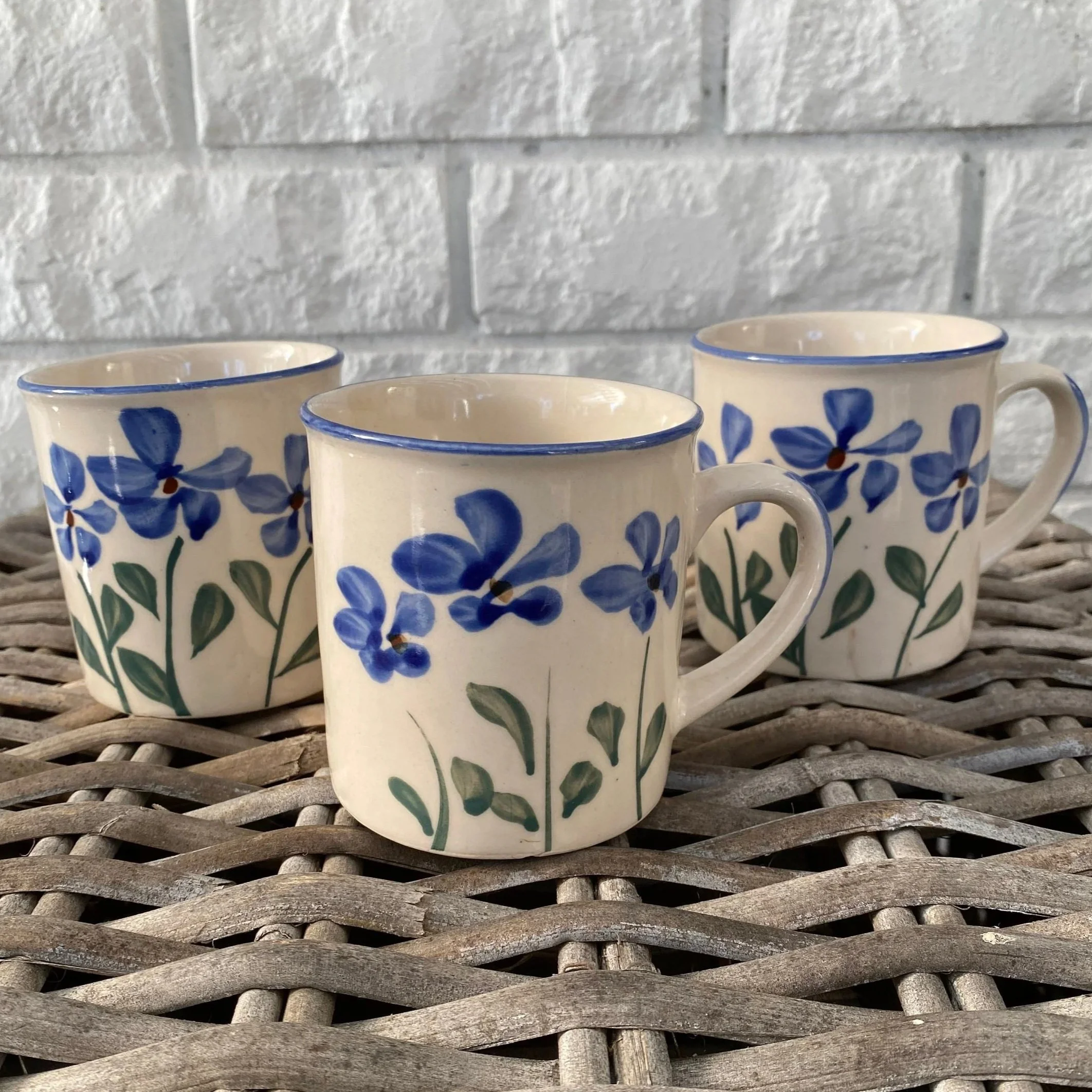 Group of three matching mugs with hand-painted blue flower design